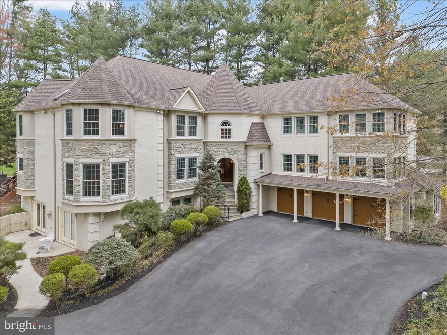 With a nod to French Normandy Architecture, this home feels both elegant and storybook-like with French charm and refinement. This stately home presides over 3-acres on a corner lot with a welcoming circular drive in the heart of Clarksville, Maryland.  Signature elements of this picturesque home include a mix of stone, stucco, brick and quoin corners with a central turret tower and arch celebrating entry into a pair of arched wood doors. 

Inside, a dramatic two-story foyer and gracious curved stair encircles a sparkling crystal chandelier and rises to a richly paneled gallery wall in the round above. Adjacent to the foyer a sweeping arched opening sided by a pair of coupled columns that announce entry from the foyer into the living and dining formals. Both formals are dressed with marble floors and crown moldings  with cove lighting. In the dining room, light streams through a bay window on one side, and opens to the kitchen on the other side.

The spacious eat-in kitchen features commanding central island and a gas cooking station with two pendants is surrounded by cabinetry, stainless steel appliances, and a corner walk-in pantry. The adjacent breakfast table area is sided by a secondary extended bank of cabinetry with a planning desk and display wall cabinets.  Opposite the planning desk is an atrium door leading to a screened dining deck with a vaulted ceiling, and two screened doors leading to the rear patio and lawn.  Thoughtfully designed, the floor plan unfolds into a wrap-around wet bar before transitioning into a storied great room defined by rich paneling, a wall of stacked windows and a gas fireplace articulated with two overmantels, a lighted art niche, and paired columns. French doors open into a den with a bay window currently used for media entertainment.  The main level is completed by a powder bath, a laundry center, a generously sized library with a bay window, built-ins and rich paneling. Three steps up from the main is a flex bedroom and elaborate exercise room outfitted with space for work-out equipment, cushioned carpet for yoga, and a mirrored wall with barre option.  Inspired by French architecture, a spiral stair rises from the exercise room to the sprawling primary suite on the upper level.  Upstairs, the curved central stairs and landing are encircled by handsome gallery paneling that opens to a private luxury primary suite and spa-like bath on one side, and a secondary paneled hall with three additional en-suite bedrooms in a separate wing.

Downstairs, a fully finished lower level is designed to accommodate a variety of entertainment venues.  New luxury vinyl floors define the kitchenette area with wet bar and coffee bar, a full bath, a billiards room, and an adjacent flex room that could become Au-pair quarters. On the other side, there is a second full kitchen and dining area with a walk-out patio that opens to a generous theater room complete with projector, and risers. The lower is completed by a second lower full bath.  In addition to the walk-out patio, and screened dining porch, this stunning property boasts a three-car side loading garage, front and back lawns, garden beds, and two rear patios. Do not miss this opportunity to enjoy elegant living with upgraded amenities and geothermal for low-cost energy.