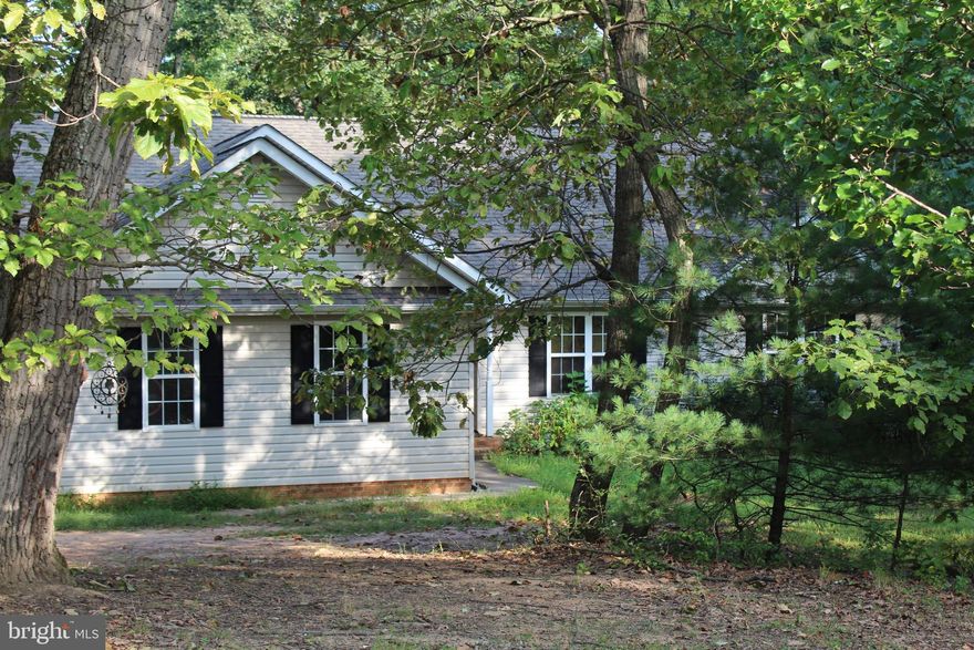 One level living on 2 acres only 5 minutes from town.  Fully finished basement with 2 additional Br's, full bath and rec room on lower level with wet bar.  Very private wooded lot.   Well and septic.  main floor flooring is hardwood  floors, bamboo in 3 bedrooms and ceramic in the kitchen.  lower level is carpet.  Great room with vault and gas fireplace.  come see!