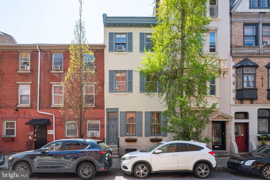 Rittenhouse Square townhouse with TWO CAR off-street parking spaces, landscaped brick patio and garden, 3 bedrooms with en-suite baths plus family room, half bath and finished basement. Fantastic location between Fitler and Rittenhouse Squares. Unusual opportunity for a street-to-street property that backs onto the 2000 block of Waverly Street. Front door entrance on Pine Street though foyer to pretty living room with wood floors, decorative mantel and historic 1850s curved banister. Hallway with spacious coat closet leads to dining room with latticed China cabinet. L-shaped eat-in-kitchen with granite countertops, built-in microwave, under cabinet lighting and tile backspash. Brick patio and garden with mature trees and door to 2 rear parking spaces on Waverly Street. Second floor landing has another large closet. Rear primary bedroom with spacious closets and en-suite marble bath with stall shower and linen closet. Second floor front is a spacious family room, den or library with shelving, wood burning fireplace and wood floors. Third floor has two bedroom with en-suite baths and great closets. Basement front is finished with built-in bookshelves, half bath and was used as a playroom and hobby area. The rear basement hold the mechanicals, laundry and additional hobby space.
