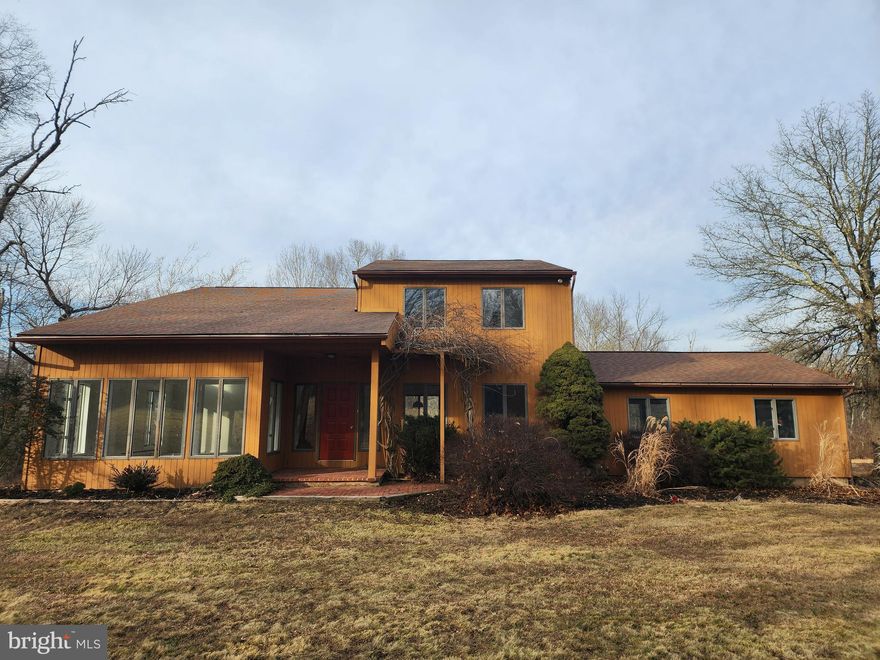 Travel down a long private driveway to discover the perfect blend of privacy and potential at 130 Pine 
Lane.  Situated on 7.6 acres of pristine wooded land featuring a meandering stream, this 4-bedroom, 4-bath contemporary home offers a rare architectural foundation for a high-end custom renovation.
The home’s striking sunroom, with its soaring cathedral ceilings and walls of glass, captures panoramic 
forest views and serves as the ideal centerpiece for a modern redesign. The open-concept kitchen and 
family room flow seamlessly onto a massive multi-tiered deck, perfect for indoor-outdoor entertaining. With a first-floor guest suite and a dedicated recreation wing, the footprint is as functional as it is versatile. Key Property Features: * Exceptional Utility: A 2-story barn garage accommodates 4+ vehicles with a sprawling upper loft. The walk-out basement includes a grade-level door designed for tractor access and equipment storage. Enjoy total serenity with a private stream and dense woods, all while being minutes from downtown  Newtown. * Compound Opportunity: This property is being offered as a 7.6-acre estate. The adjacent 2.5-acre subdivided buildable lot is also available for purchase (see separate listing), offering the unique chance to create a 10.1-acre private compound.