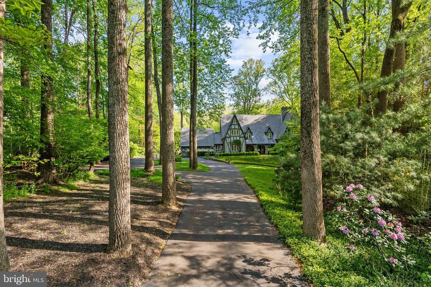 10205 Cedar Pond Drive is where the Fairy Tale Begins.  With over 7400 Sq. Ft. of Living Space this  HIDDEN OASIS IN ONE OF THE MOST SOUGHT-AFTER AREAS OF VIENNA.  Magnificently sited on 1.23 acres backing to 15 acres of woods, this exceptional estate offers unmatched privacy and character while remaining just minutes from McLean, Tysons, and Reston Town Center.
The approach begins with a gentle hilltop location and meticulously landscaped grounds framed by mature trees, setting the stage for the romantic architecture and elegant interiors. At the heart of the home, a stunning custom kitchen by Apex Homes features custom Neff cabinetry, professional-grade Wolf and Sub-Zero appliances, and an expansive design ideal for both everyday living and entertaining. The adjoining formal dining room is highlighted by a dramatic plaster groin-vaulted ceiling and walls of windows that capture serene views of the landscaped grounds and pool beyond. A sun-filled garden room opens directly to the rear terrace, blending indoor and outdoor living. The spacious main-level family room adjoins a paneled study providing the option of a first-floor primary suite.
The rear garden is a resort-like destination, featuring stone terraces, formal gardens, fountains, and mature trees—all anchored by a resort-style swimming pool, spa, fire pit, and two custom gazebos.
Upstairs, the primary suite offers a fireplace, an extraordinary custom dressing room with handcrafted burled walnut and mahogany cabinetry, and a spa-inspired bath designed for relaxation—two additional bedrooms on this level feature cathedral ceilings and abundant windows overlooking the gardens.  The lower level provides remarkable flexibility for guest accommodations, fitness, media, or lounge space.
Every room reflects a commitment to quality and craftsmanship, with timeless design, abundant natural light, and a seamless blend of European character and luxury. This is more than a home—it’s a lifestyle.