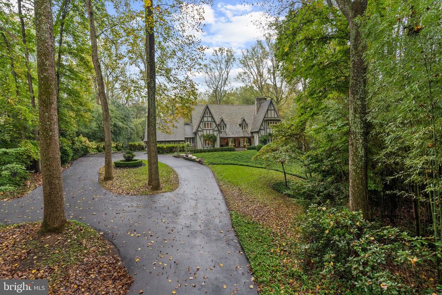 10205 Cedar Pond Drive is where the Fairy Tale Begins.  With over 7400 Sq. Ft. of Living Space this  HIDDEN OASIS IN ONE OF THE MOST SOUGHT-AFTER AREAS OF VIENNA.  Magnificently sited on 1.23 acres backing to 15 acres of woods, this exceptional estate offers unmatched privacy and character while remaining just minutes from McLean, Tysons, and Reston Town Center.
The approach begins with a gentle hilltop location and meticulously landscaped grounds framed by mature trees, setting the stage for the romantic architecture and elegant interiors. At the heart of the home, a stunning custom kitchen by Apex Homes features custom Neff cabinetry, professional-grade Wolf and Sub-Zero appliances, and an expansive design ideal for both everyday living and entertaining. The adjoining formal dining room is highlighted by a dramatic plaster groin-vaulted ceiling and walls of windows that capture serene views of the landscaped grounds and pool beyond. A sun-filled garden room opens directly to the rear terrace, blending indoor and outdoor living. The spacious main-level family room adjoins a paneled study providing the option of a first-floor primary suite.
The rear garden is a resort-like destination, featuring stone terraces, formal gardens, fountains, and mature trees—all anchored by a resort-style swimming pool, spa, fire pit, and two custom gazebos.
Upstairs, the primary suite offers a fireplace, an extraordinary custom dressing room with handcrafted burled walnut and mahogany cabinetry, and a spa-inspired bath designed for relaxation—two additional bedrooms on this level feature cathedral ceilings and abundant windows overlooking the gardens.  The lower level provides remarkable flexibility for guest accommodations, fitness, media, or lounge space.
Every room reflects a commitment to quality and craftsmanship, with timeless design, abundant natural light, and a seamless blend of European character and luxury. This is more than a home—it’s a lifestyle.