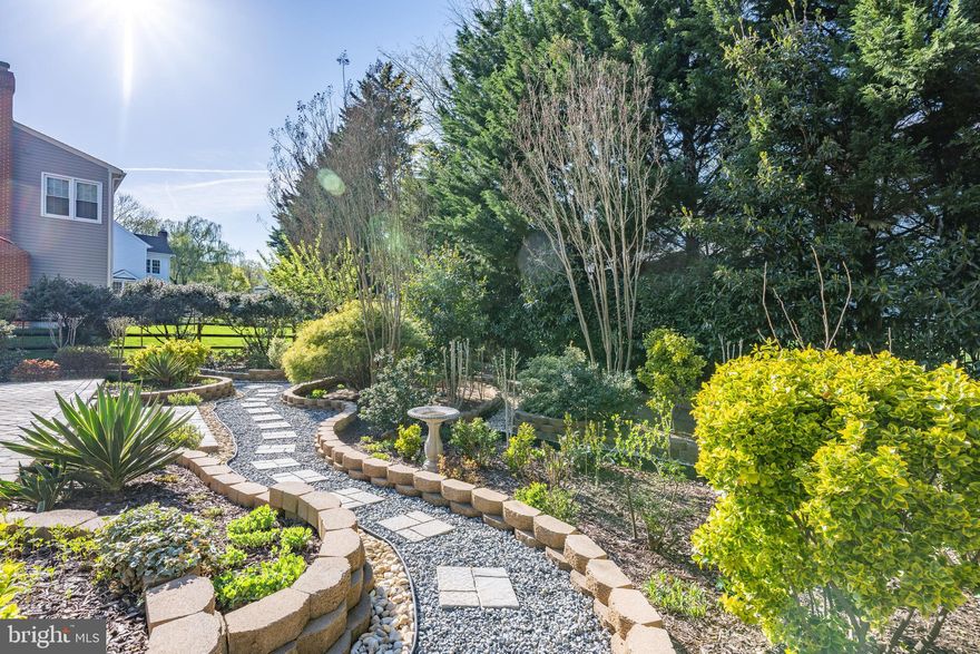 Beautifully Renovated 5BR/4.5BA Colonial with Show-Stopping Gardens in Piney Glen Village-Churchill High School Cluster

Fully renovated from top to bottom in 2009 and boasting one of the most breathtaking gardens in town (over $30K spent on flowers alone!), this exceptional 5-bedroom, 4.5-bath Colonial in sought-after Piney Glen Village offers luxurious living inside and out.

Step inside the two-story foyer and be greeted by French doors leading to a sunlit library/home office. The formal living and dining rooms feature elegant columns, triple crown molding, and large windows that flood the space with natural light.
At the heart of the home is a stunning gourmet kitchen, redesigned with entertaining in mind. Enjoy solid wood cabinetry, granite countertops, decorative brick backsplash, and top-of-the-line KitchenAid stainless steel appliances, including a double oven with a convection/microwave combo. A spacious center island (with capped gas line for optional cooktop), deep sink with backyard views, and abundant storage options, including a Lazy Susan, pull-out drawers, and double-door pantry, make this space as functional as it is beautiful. A separate wet bar with beverage fridge adds the perfect touch. Durable tile floors lead directly out to a tranquil backyard oasis.
Adjacent to the kitchen, the inviting family room features 10-foot ceilings, gleaming hardwood floors, a cozy wood-burning fireplace, recessed lighting, and four oversized windows overlooking the lush gardens. An oversized two-car garage with built-in storage completes the main level.
Upstairs, find five generously sized bedrooms and three full bathrooms, all with high-quality new carpeting (installed in 2022). The luxurious primary suite impresses with cathedral ceilings, recessed lighting, a relaxing sitting area, and two walk-in closets with windows. The spa-inspired en-suite bath includes a jacuzzi tub, double vanity, large glass walk-in shower with bench, and a private water closet. A guest suite offers its own private bath, while three additional bedrooms share a well-appointed hall bath. One bedroom even features a charming octagonal window and walk-in closet with attic access for extra storage.
The expansive finished lower level provides endless possibilities with a large double recreation room, recessed lighting, plush carpeting, and direct walk-out access to the backyard. A brand-new full bathroom, a bonus room ideal for a home gym, guest room, or second office, and a spacious laundry/utility room (featuring a Whirlpool washer and brand-new 2025 Whirlpool dryer) round out the space.
The backyard is a true retreat, lush, colorful, and beautifully landscaped with a brick paver patio, crape myrtle, hydrangeas, and more. Enjoy seamless indoor-outdoor living with direct access from both the kitchen and the lower level.
Recent updates include:
* New Roof (2017)
* Zoned HVAC System (2012)
* Upstairs Carpeting (2022)
* Brand-New Dryer (2025)
Enjoy the full range of community amenities including a swimming pool, clubhouse, tennis and basketball courts, tot lots, walking paths, and more, all conveniently close to shopping, dining, and major commuter routes.