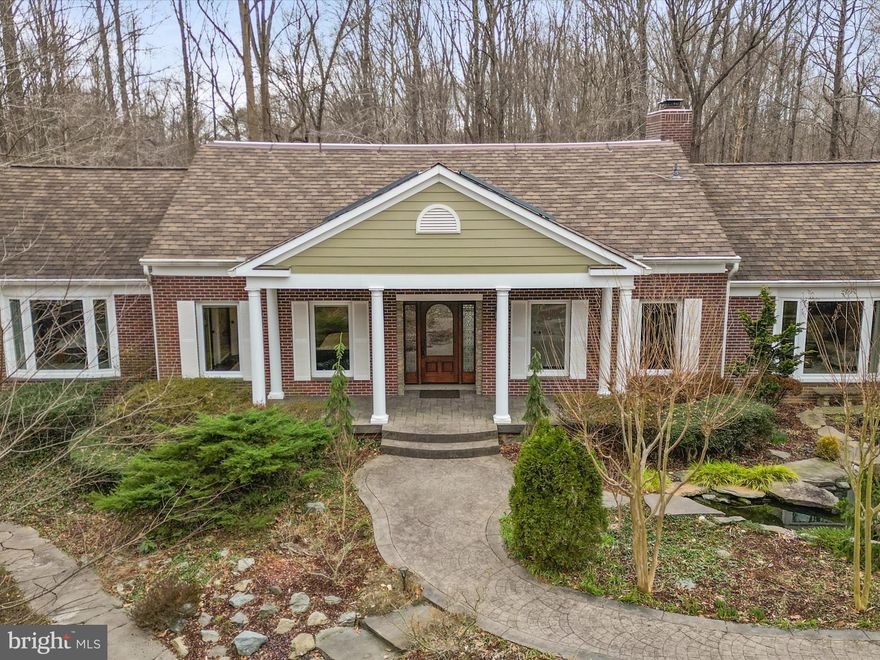 Live in harmony with nature in your highly energy-efficient 4 bed 3.5 bath home with discrete solar panels, silent backup battery power and 4-zone geothermal heating/cooling that costs about $840 per year to run. The privacy and flow of this home offers indoor / outdoor living with a covered deck that shelters you from sun and rain for dining and relaxing, stone patio with a fireplace, and solar-heated swimming pool. Deer fencing surrounds the 3.7 acre park-like property that includes a creek, small wildlife pond with water lilies and a breathtaking range of mature plantings of trees, shrubs and flowers that delight year-round. Trails entice you to discover the secrets of this organic yard in which birds, butterflies and wildlife thrive, minutes from shops, restaurants and commuting options. The spacious first floor primary bedroom offers separate his and her walk-in closets and en-suite luxuries including a towel warmer and copper tub, while the second bedroom also has its own full bath. The kitchen offers high-end Cafe and Miele appliances and an eating area with a wall of windows, flowing to a dining room with wood-burning fireplace insert, a living room with second fireplace and integrated surround-sound, and a sound-insulated office. Solid wood hand-scraped hickory flooring with wainscoting and crown molding continues upstairs leading to two additional bedrooms and a large bathroom. Storage abounds with three walk-in attic areas. A finished walk-out partial basement with insulated and carpeted flooring provides an exercise area, kids play area, or media room. The inviting low maintenance exterior features brick, architectural shingles, luxury PVC decking, and custom solid wood entry and garage doors. HOA clears snow, maintains private roads, and offers miles of neighborhood woodland trails.
Plus you are so close to the town of Clifton with shops and restaurants, Burke Lake Park and the best schools around.  WOW a 10+++