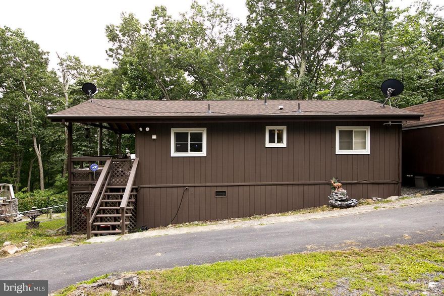 Private 1.45 acre corner lot. Move in ready. Sit on your wrap around deck and relax. Living room with gas Fireplace. 2 bedrooms and 2 full baths a den  and an xtra room. Windows 4 years old and Heat Pumps 2 years old and roof 1 1/2 years old. Above ground pool with heater conveys. Paved circular driveway. Must See. call today!