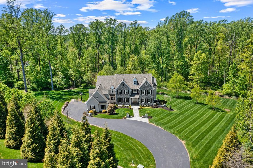 Welcome to 2207 White Horse Road, a stunning stone estate set on 2.6 private acres within the highly sought-after Tredyffrin/Easttown School District. Offering over 9,100 square feet of beautifully designed living space, this exceptional residence combines timeless architecture, elegant finishes, and thoughtfully designed indoor-outdoor living.

Entering through the elegant stone pillars and traveling down the private tree lined driveway, this magnificent 6 bedroom, 5.2 bathroom home sits gracefully on professionally landscaped grounds surrounded by mature trees and backing to acres of farm land. The stately stone façade and classic architectural details immediately set the tone for the refined interiors that await inside.
Step through the front door into a dramatic two-story foyer with an open balcony overlook, where rich hardwood flooring, detailed millwork, and beautifully proportioned spaces create an atmosphere of warmth and sophistication. The main level is designed to accommodate both elegant entertaining and everyday living, offering a formal living room with a gas fireplace and a spacious dining room with adjoining butler’s pantry. A private home office with custom built-ins provides the perfect work-from-home setting, while the thoughtful layout allows living spaces to flow seamlessly from one to the next.
At the heart of the home is a beautifully appointed chef’s kitchen featuring custom cabinetry, a large center island with seating, quartz counters, Wolfe and Sub-Zero appliances, and designer lighting. The kitchen opens effortlessly to a sun-filled breakfast room that exits to the outdoor space while the family room with vaulted ceiling and gas fireplace also offers french doors to the exterior, creating an ideal environment for entertaining family and friends and offers picturesque views of the grounds.
Upstairs, the primary suite serves as a private retreat, offering a spa-inspired bathroom featuring dual vanities, a soaking tub, and enlarged glass-enclosed shower. Two spacious walk-in closets with built-in systems provide abundant storage and organization. There are two other bedrooms with their own private bathrooms and walk-in closets while two additional bedrooms share a hall bathroom.
The expansive finished lower level adds exceptional versatility to the home. A custom bar area creates the perfect setting for hosting guests, while the spacious lounge area provides room for movies, games, and casual gatherings. The fitness area with sauna is no average gym but one made for a true fitness enthusiast- it is sure to impress! This level also houses the 6th bedroom and an attached full bathroom with a stall shower - perfect for guests or for a quick rinse post your work-out.
The outdoor living space is equally as impressive. A beautifully designed custom stone patio provides multiple areas for entertaining and relaxing, including a built-in outdoor kitchen and grilling station, a dedicated dining space for al fresco meals, and a striking fire pit lounge that invites gatherings under the stars. The expansive lawn and wooded backdrop offers both privacy and natural beauty, creating a peaceful retreat.
Completing the property are a three-car garage with built-in storage, an oversized driveway, and professionally landscaped grounds, all designed to complement the home’s elegant estate setting. 2207 White Horse Rd is ideally located - walkable to Episcopal Academy, minutes to other top private academies, and close to the Paoli train station and the shopping/dining options in Newtown Square, Wayne and KOP. Offering the rare opportunity to enjoy privacy, luxury, and convenience in one of the Main Line’s most desirable locations- Call today for more information; this property is not to be missed!