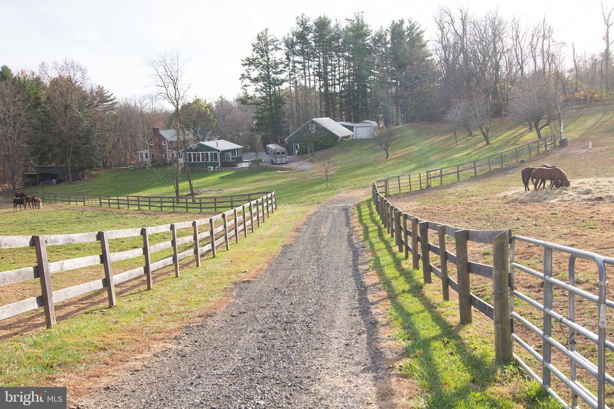 THIS IS THE HORSE FARM YOU HAVE WAITED FOR!! A true equine farm sitting on 21 acres in bucolic Carroll County.  Driving through the gate, you will fall in love with the spring fed pond, featuring a large fountain in the middle and a maintenance free dock (with electric). The grandkids can fish for Crappie, Bass, and more! Continue up the drive to the main house, the 3 car oversized detached garage with apartment above it, and the enclosed pavilion/man-cave/entertainment oasis!! The house boasts 4 bedrooms, 2 full baths, and almost 3000 square feet above grade! The gorgeous remodeled kitchen is the centerpiece of the open floor plan. Granite counters and island, soft-close cabinets, stainless steel appliances and range hood, and gas stove! The living room and dining room  fireplaces both have wood burning inserts that not only warm the whole house, they are amazing to look at! Most of the main floor has Old Barn wood from North Carolina. The office, large pantry, full bath,  large laundry/mud-room make up the rest of the main level. 4 bedrooms upstairs, with the primary bedroom featuring a walk-in closet. The basement has tons of storage! Head across the driveway to the entertainment room. This huge, glassed-in pavilion is perfect for hosting the big game or having an "inside cookout"! Ceiling to floor glass windows overlooking the farm make this an amazing place to hang out. The ductless heating/cooling system, R19 Batt and R38 insulation make it extremely cozy! Now head over to the enormous garage with 3 large bays with doors , and one bay used for a work bench/storage area. There is heating and cooling in the garage.  Above the garage is a 1-bed/1-bath apartment, also with ductless heating and cooling. Perfect for an in-law, farm help, or just as an income producing apartment! 2 more sheds for farm supplies make up the cluster of buildings around the driveway.  But the best is yet to come! Life is about horses!! The current owner raises Thoroughbreds and has turned what was once a cattle farm into a true horse farm.  He created  6 pastures with new post and rail wood fencing. All the pastures have water run to them, and the main pastures also feature automatic waterers. The main barn has 6 stalls ( some oversized for mares and foals), a connected run in shed, and water and electric. The second barn is in a separate field with 3 stalls with water and electric, and a separate run-in shed. Plenty of mature trees (and a Forestry Stewardship program) make for an idyllic pastural landscape! A beautiful scene to wake to every morning! With a ratified contract, the owner is willing to throw in his tractor, horse trailer, and ATV.