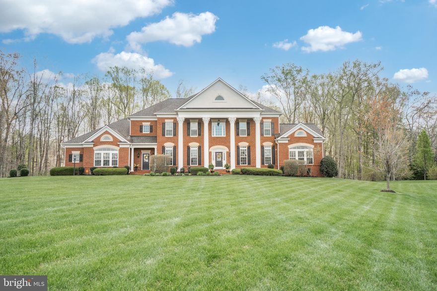 Wow! This beautiful brick Estate home on over 3 acres is waiting on you to make yours!  Beautiful large, professionally landscaped yard,  leading up to the grand entrance! A warm inviting atmosphere awaits!  Large front porch with impressive columns going across the front.  Walk into a splendid grand entrance formal two-story foyer with hardwood floors throughout the main level! To your right you will enter the living room with a double-sided fireplace that leads you into the side sunroom.  This sunroom is stunning with lots of windows.  Perfect for a reading room, additional home office, or music room.  Make your way around the corner to the home office for teleworking or to use as a home library.  Relax in the oversized family room with a beautiful stone fireplace, & box beam ceiling! Enjoy watching tv from the massive gourmet eat-in kitchen.  This is a chef lover's dream!  Stainless appliances which include the dishwasher, double wall oven, built in microwave, 5 burner gas cooktop, garbage disposer, and granite countertops!  The walk-in pantry leads you to the mudroom that you can also enter through the front of the home for a double entrance.  The mud room will take you into an oversized 3 car sideload garage with new, stylish, updated garage doors.  This garage has Fluorescent lighting, 2 automatic garage doors with remotes, utility sink, & a built in hose bib.  The butler's pantry will lead you into a sizeable dining room with plenty of space for all of your family meal gatherings. As you make your way up the stairs you will reach the enormous Master Suite with Tray ceilings, & double-sided fireplace! The Master Bath has ceramic tile, sunken tub, vanity area with double sinks.  Live in style with this dressing room size closet!  Upper-level laundry off of the Master Bedroom includes a laundry sink, washer & dryer & cabinetry above.  Each spacious bedroom is an en-suite having your own full bath and sizeable closets! As you go back downstairs the kitchen will lead you to a massive sunroom that will take you out to a 40x20 low maintenance composite deck. Make your way downstairs to a huge basement that has a massive size finished rec room area! It allows plenty of entertaining space for having friends over to watch a movie or fun game nights! There is a bedroom finished that is not to code but could be used as a craft room or hobby room.  This room leads to a full bath with ceramic tile floor and ceramic sound with an upgraded sink and fixtures.  Your company can have their own space and privacy.  You can finish additional rooms!  The rooms can be a media room,  home gym,  game room or two more bedrooms!  The basement leads you out to the backyard through a walkup & a walkout! Awaiting you is a Massive stone patio that extends under the deck to a beautiful 40x20 inground pool, w/built in firepit & built in Spa.  The pool is heated, with a refreshing  waterfall, & color changing pool lights!  There is a stylish iron fence for privacy.  The backyard backs up to trees, so you have your own private getaway retreat.  In the backyard there is an oversize shed that has full electric and is shop ready! Under the deck you will find a stone patio with a brick underlay instead of concrete which gives it a more finished look for another relaxing space.  Additional features include a 9-zone sprinkler system, 3 fireplaces, Satellite dish, humidifier on HVAC Unit, 75-gallon hot water tank.  3 HVAC units, ceiling fans throughout, two laundry areas.  The basement already has the rough in for a 6th bathroom, and bar area. Upgraded Brazilian Cherry hardwood flooring! Peach, Pear, Cherry & Apple trees, Weeping Willow & Forsythias to make it complete. Close to I-95, commuter lot, grocery, and schools.  Top rated schools!  Mountain View High School, Rodney Thompson Middle, and Margaret Brent Elementary. This is the total package! You will never want to leave!