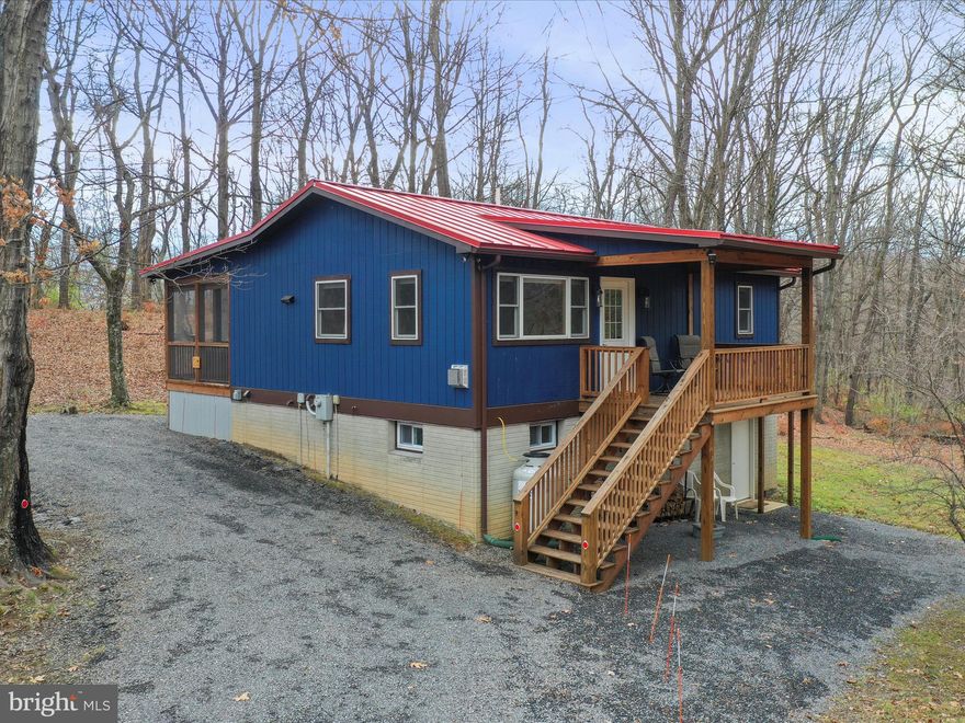 Discover this beautifully renovated modern cabin, nestled in West Virginia's scenic charm. Thoughtfully designed for relaxation and practicality, this home features an open, light-filled layout that invites you to unwind. The living area features a charming stove, perfect for cozy evenings. The kitchen combines style and function with sleek stainless steel appliances, granite countertops, and carefully chosen tile details.

The primary bedroom offers breathtaking mountain views right from the window and includes a private ensuite bath. A second bedroom and adjacent full bath provide added comfort and convenience. Downstairs has been transformed into a versatile den, game room, or TV space with a laundry space, while the other half offers abundant storage and room for hobbies.

Step outside to the screened-in deck, where you can enjoy West Virginia’s changing seasons. This outdoor space is perfect for sipping morning coffee, grilling, or dining al fresco. A circular driveway ensures easy access, and thoughtful touches like an electric car charging station, or a fire pit to gather with friends, and a perfectly placed bench to soak in the views make this property truly special.

The home is as practical as it is beautiful, featuring an updated water treatment system, a durable metal roof, and fiber-optic internet for seamless connectivity. Currently an active short-term rental, this property offers the unique opportunity to be purchased fully furnished, making it an effortless investment or a ready-to-enjoy retreat. 

All of this is just two hours from DC but feels like a world away. Nestled just outside George Washington National Forest and the Trout Pond Recreation Area, you’ll find endless opportunities for outdoor adventures, from swimming and kayaking to fishing. For shopping and dining, both Wardensville and Mathias are conveniently located just 20 minutes away in either direction.

Don’t miss your chance to experience this modern mountain getaway. Schedule your showing today!