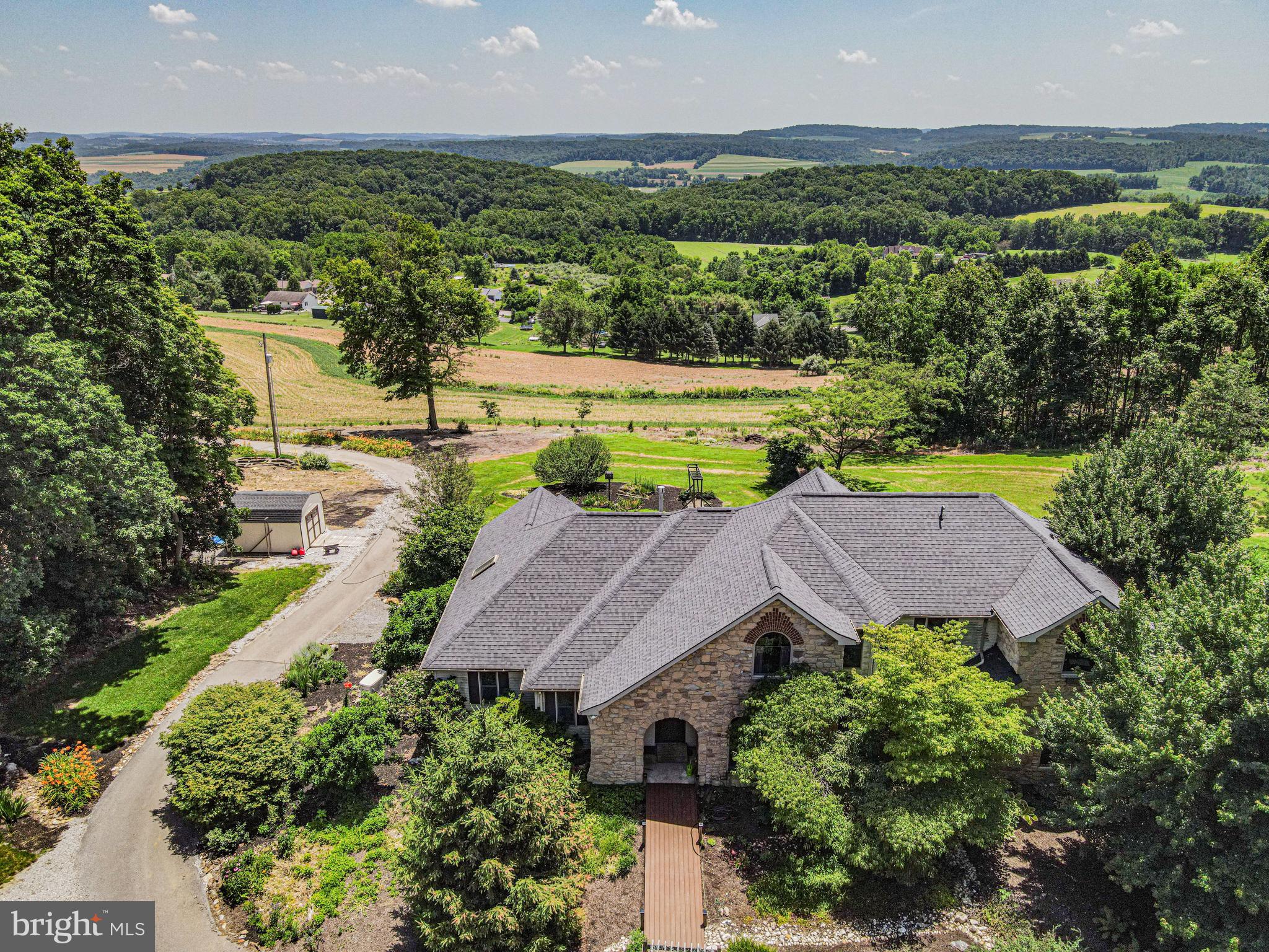 Enjoy luxury living in this stunning 5 bedroom, 4 bath home nestled on 30+ acres in Southern York County. At nearly 4,000 sq ft, the open-concept kitchen, living and dining areas offer a seamless flow for entertainment, while the sunroom—with its charming wood stove and artisan tile flooring—provides a cozy retreat overlooking breathtaking, panoramic countryside vistas. A first floor master suite elevates everyday living with a private office/library, generous walk in closet, and spa inspired ensuite boasting both a walk in shower and a soaking tub. A first-floor laundry/mudroom adds to the convenient living of this home. The walk out basement offers endless storage potential and easy access to outdoor space. The whole house generator ensures uninterrupted comfort. With approximately 18+ acres of tillable land, a dedicated shed for gardening and beautiful flower beds, this property isn’t just a home, it’s a private oasis, perfect for both lavish gatherings and quiet reflection amid nature’s beauty.