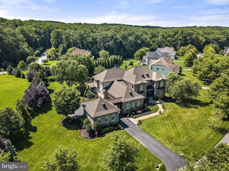 Welcome to a world of luxury and elegance! Prepare to be mesmerized by this extraordinary custom built mediterranean style estate with over 9000 sq ft of living area, meticulously designed with the utmost attention to details and adorned with countless upgrades that exude sophistication.  Meticulously maintained home with lush gardens and large outdoor areas await your arrival to this stunning home. Step inside and be captivated by the harmonious blend of timeless beauty and modern allure. Your eyes are immediately drawn to the exquisite grand foyer leading to a patio overlooking the magnificent  backyard and fenced  mineral pool with brand new pool equipment, leaving a lasting impression of grandeur. (PLEASE watch Virtual Videos ). Indulge in the epitome of culinary artistry in the gourmet chef's kitchen, where every feature has been thoughtfully crafted to enjoy every meal. One year young high-end appliances stand as a testament to uncompromising quality, while the sleek design seamlessly marries functionality with style. The main level also boasts a huge office,  a butler's pantry off of the large dining room, and a breakfast area. The open-concept kitchen overlooks the family room and fireplace, and connects to a large mudroom and the attached garages. Among the oversized five en suite bedrooms on the upper and lower levels, unwind in the luxurious embrace of the enormous primary suite, an indulgent sanctuary that invites you to surrender to tranquility. Immerse yourself in the lavishness of the surroundings, where elegance and comfort converge effortlessly. The walk-out lower level unveils a world of possibilities. Discover the custom drapery, wood blinds all through the house, two staircases, exercise room with mirrored walls, pool changing closet and full pool bathroom, motorized screens on deck, indoor sprinkler system, and smart enabled system to control the whole house, outdoor gas fireplace, pergola, dry sitting under deck, outdoor storage closet, a summer kitchen with built-in Lynx 42" grill, built-in refrigerator, outdoor speakers and mahogany ceiling. The lower level also features a generous sized living area, a bedroom and two full bathrooms, and a large theater room with a projector and 135" movie screen. As you explore further, you will discover the enchanting sanctuary of the private backyard . Situated just minutes away from historic Ellicott City, shops, and restaurants, this prestigious residence combines elegance and convenience in perfect harmony.  This magnificent abode is more than just a home; it is an embodiment of exquisite taste and refined living. Welcome to a world where dreams become reality. With an abundance of splendor, this home is destined to capture the hearts of those seeking a life of refined luxury.
