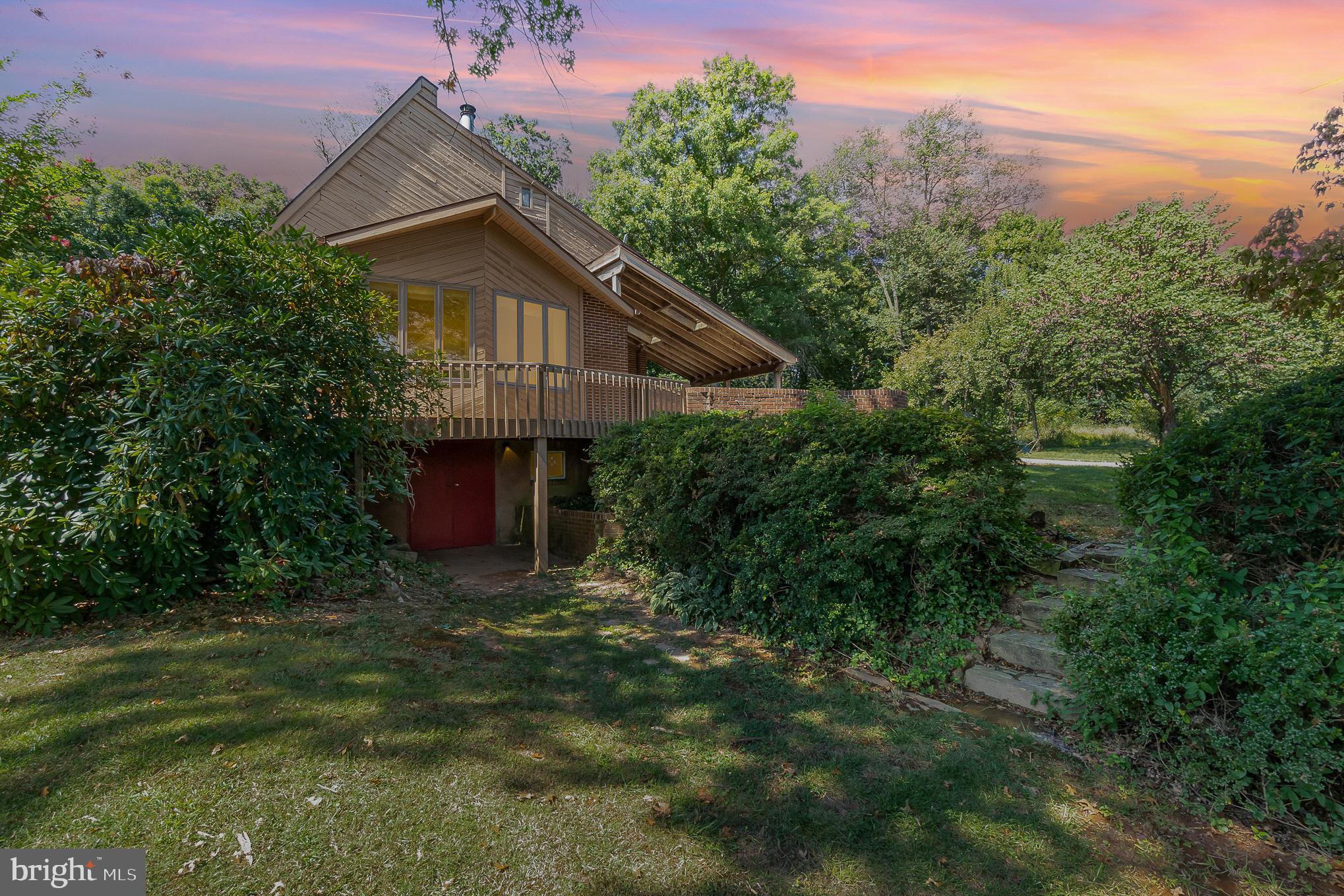 Welcome to your private and peaceful retreat in Jarrettsville! The mature grounds are a gardener's dream. The unique architecture of this home features a touch of contemporary, mid-century modern and blends perfectly into nature, bringing the outdoors in. The wood plank exterior shows off the unique angles of this custom-built home. Large windows throughout the first floor allow an abundance of natural light to pour in. The living room features cathedral ceilings with cedar tongue and groove planking, a wood burn fireplace with beautiful cedar mantle design above and windows to overlook your deck and exterior gardens. The dining room is located off of the living room and overlooks the front deck and yard. The kitchen features a large island with an electric stove, a wall oven, roll top cabinetry, a slider to the slate stone patio and koi pond. Down the hallway you enter the first floor bedroom that has been used as a den or office. This room has a slider to the solarium with an additional koi pond! Further down the hall you will have access to your main level full bathroom and laundry room with a cedar lined closet. The second floor begins with the primary bedroom and en-suite bathroom. This wet-bathroom design includes a sunken shower area with tiled walls and floors. The second floor also includes two other bedrooms and a full bathroom with a walk-in shower. The basement has a finished room that was recently used as an office, but could be perfect for a craft room, music studio or any other hobby. There is a workshop room with benches, a storage room and a bonus room leading to the front yard that could be used for storing gardening equipment or seasonal items.