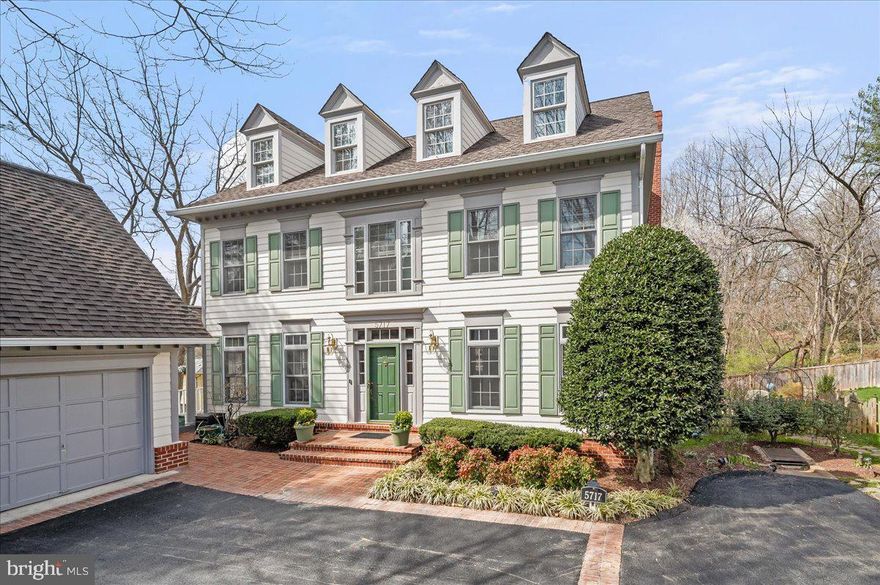 This spectacular 5 bedroom, 3.5 bath home on the coveted Trafton Place cul-de-sac in the Ayrlawn section of Bethesda is situated on a nearly one-third private acre overlooking adjoining wooded parkland, giving beautiful views, fabulous sunsets and year-around privacy, via the oversized windows and doors which open to two levels of private wrap-around decks. Just a few minutes walk to NIH and Johns Hopkins Suburban Hospital, Trafton Place is its own small hamlet of handsome, well-built homes of classic design developed by the highly regarded Mitchell & Best Company.

This home’s gorgeous foyer is flanked on either side by the generous dining room and an elegant living room. The kitchen, with extensive cabinetry and work space, offers new quartz countertops and elegant tiled backsplash, and opens to an eating area and  a beautiful family room with a wood-burning stone fireplace and plenty of built-ins. Walk out  to a large balcony with views of the adjacent forested parkland and wraps around to a breezeway that gives covered access from the house to a large two-car garage architecturally designed to tie in with the handsome, classic exterior of the home.

The large windows afford natural light throughout the first floor of the home, and the second level of the home has brand new oak floors and four bedrooms. The large primary suite features gorgeous bay windows with woodland views, walk-in closets and a brand-new renovated primary bath with beautiful shower, large soaking tub, double vanity, Porcelenosa tiles and beautiful fixtures.  The other bedrooms are a good size and the room with the floor to ceiling windows can serve as a lovely home office.

The lower level of the home features a dramatic 9’ 8”  coffered ceiling, and the large main room opens to a wrap-around deck and large back yard. In addition, there is a bedroom with full-size windows, an ensuite bath and large closet.

This elegant home has been updated with new and newer bathrooms and windows and many handsome, quality features throughout; this is a rare opportunity to own a gracious, beautifully built and updated home privately situated in the unique enclave of Trafton Place.