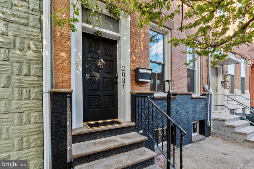 A one of a kind retreat in the city! Welcome to 2031 East Dauphin - a beautiful newly renovated and restored 5 bedroom, 2.5 bathroom home on a tree lined block in vibrant East Kensington. As you approach you'll notice the handsome ironspot brick facade and the elevated position of the home about 5ft above street level. Walk up the steps through the front door and hang your jacket or bag in the large vestibule with a scalloped glass door. Enter into the expansive great room. The property is 17 feet wide with 10 foot high ceilings, creating an incredibly spacious feel while also retaining a coziness from the character and charm of the home. The large windows allow light to flood into the home and the effect is dramatic. The original inlayed oak hardwood floors have been refinished and there are newer windows throughout the whole home. Continue back to the dining room which can accommodate a table as big as you need. Beyond, you'll find the kitchen, tastefully designed with tile backsplash, dark matte blue cabinets, brand new stainless steel appliances (range, fridge, microwave, dishwasher), and quartz countertops. Just beyond the kitchen is the laundry room/half bath with a brand new washer and dryer. Keep going and head to the big backyard, with plenty of space for a table, chairs, grill, and a bit of nature with a flowering tree and towering neighboring green pines. Back into the kitchen you'll find a back staircase where you can head upstairs to the primary bedroom with en suite bathroom. The private primary bedroom in the rear of the home is very spacious with 5 large windows that let in great natural light. Continue down the hall and notice a beautifully renovated bathroom with teal wall tile in the shower and penny tile flooring with brass fixtures. Continuing, you'll find the spacious second and third bedroom. The front bedroom boasts a charming and sizeable built-in wardrobe closet with skeleton keys original to the home. Head up to the third floor and you'll find another two large bedrooms that could also serve as work or studio spaces. There is a door to access the giant double tiered roof with a skyline view at the top, perfect for creating a roof deck. The massive basement is great for storage, creative, or flex space. In addition to the renovations throughout, other updates of note include: brand new HVAC (heat and central air), sewer line replaced, newer roof, knob and tube completely removed, new electric service cable, new windows, refinished hardwood floors and more! With so much space, original charm, and a fantastic location that's walkable to some of Philly's best restaurants, coffee shops, and bars with easily accessible public transportation to the rest of the city, you'll want to check out this truly special home.