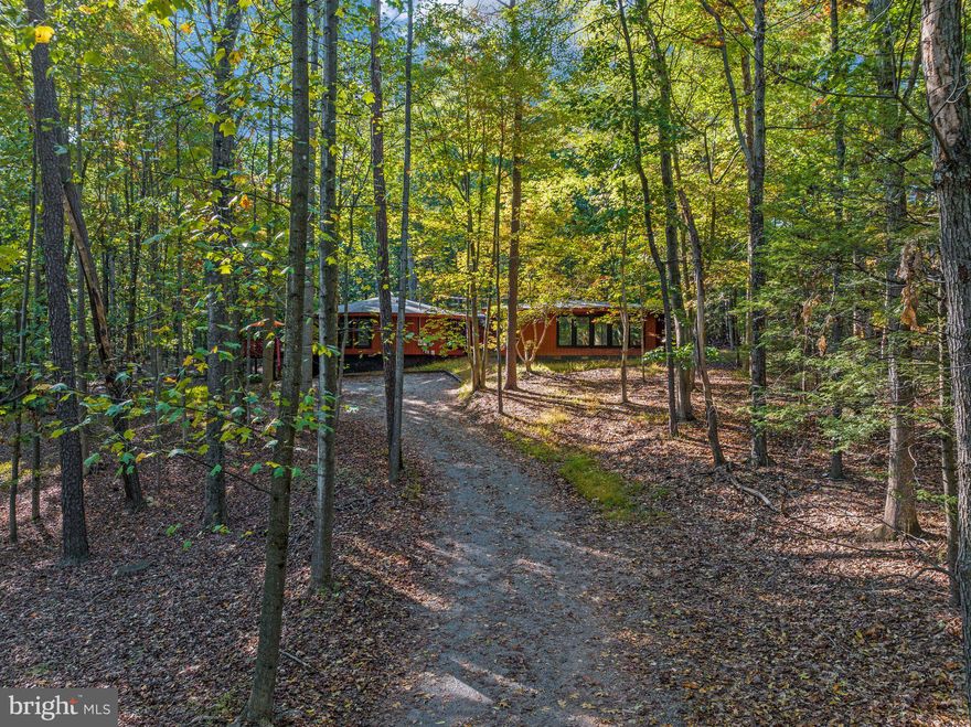 Welcome to your own little oasis! This stunning contemporary cabin is nestled on a wooded lot in The Woods Resort, offering the perfect combination of serene surroundings and modern luxury. With breathtaking views from the floor to ceiling windows and an open floor plan that seamlessly blends curves and straight lines, this home is an architectural masterpiece.

Step inside and pleasantly discover a beautifully updated living space, complete with lvp flooring, skylights and  floor to ceiling windows throughout that not only bring the outdoors in creating a nature paradise, but also floods the space with natural sunlight. The unique round design of the main gathering area creates and open floor plan that is bright and airy; perfect for entertaining as you flow from the kitchen to the dining and great room areas. 

The kitchen updated in 2021, boats new appliances, modern cabinetry with soft close hinges and floating shelves. The moveable kitchen island provides additional space for creating a culinary masterpiece and  provides additional storage space. 

The round portion of the home is completed with 2 spacious bedrooms also with floor to ceiling windows and lvp flooring, and a designer bath that offers tastefully designed tile flooring and shower walls. 
A walk down the hall leads to the oversized primary bedroom with its decorative wood beamed ceiling where you can cozy up to the wood stove to relax and unwind. Sliding glass doors along one wall of the primary bedroom  lead you to a deck where you can enjoy a quiet space to read, rest, stargaze, maybe a little yoga, the possibilities are limitless. The primary bath is in a space unto itself.  When you step into the spa like bath you're immediately delighted by a sleek floating tub, perfect for indulging in a relaxing soak after a long day. The tile flooring is a relaxing neutral color with a whimsy of circle in a square playing off of the design of the home. 

Outside, you'll find multiple decks where you can enjoy the outdoors, take in the peaceful view, watch the deer as they pass thru the yard and stargaze at the evening sky. Whether you're hosting a summer barbecue or stargazing under the clear night sky, this backyard has it all including a HOT TUB!

This home has everything to offer including a Membership to The Woods Resort; a community that offers an abundance of amenities. With a membership, you have access to 2 outdoor pools, indoor pool, indoor and outdoor pickle ball, tennis ball, basketball, racquetball courts and a private fitness center. Amenities that do not require a membership include, tot lots, lakes for catch and release fishing, Sleepy Creek Spa where you can enjoy self care services, the Clubhouse Grille & Pub for a quick pub fare style meal and you can enjoy public pay golfing at either the Stony Lick or Mountain View golf course.  
Don't miss out on this incredible opportunity to own your own oasis and start living the life you've always dreamed of whether it's for year round living, your second home or an airbnb! Schedule your appointment today to view this amazing home!
