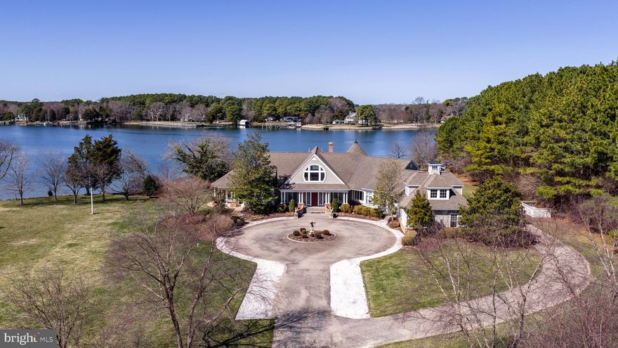 Island Creek Estate — rare total privacy, deep water dockage, meaningful architecture, and superb build quality all intersect at this remarkable, truly one-of-a-kind waterfront offering. Set on approximately 6 acres of park-like grounds with 500± feet of shoreline and 6’± MLW, the property offers exceptional water access along the peaceful expanse of Island Creek. The setting is serene and private, with a gracious approach that complements the estate’s architectural presence. Impeccably built with careful attention to detail, the residence offers 4 bedrooms and 3.5 baths within a thoughtfully designed floor plan that maximizes natural light and water views. The living room, kitchen, and dining area flow comfortably together, creating a spacious central gathering area framed by expansive windows overlooking the creek and anchored by a fireplace. The kitchen is generously sized, featuring a substantial island, quality finishes, and an inviting eat-in area suited for both everyday living and entertaining. Outdoor living is equally compelling, with a screened porch overlooking the water and an in-ground pool set against sweeping creek views. The private pier provides deep water dockage, ideal for boating enthusiasts seeking immediate access to the Chesapeake Bay watershed. A finished rec room above the attached garage offers flexible use as a media room, office, or fitness space. In addition to the attached two-car garage, the property features a substantial detached multi-bay garage equipped with a hydraulic vehicle lift, air compressor, and rough-in for a future bath — an exceptional amenity for car collectors, hobbyists, or workshop space. This exceptional Island Creek estate combines craftsmanship, privacy, and premier waterfront living in a setting that is both refined and enduring.