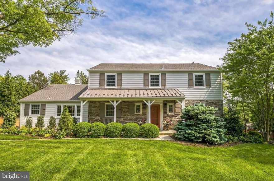 Welcome to 317 Powderhorn in Militia Hill, the most sought-after community in Whitemarsh Township. This beautifully maintained 4-bedroom, 2.5-bath home with partial stone façade and a charming covered front porch with a standing seam metal roof is just the beginning of what this exceptional property offers. Situated on an expansive, private lot, this home combines timeless elegance with functionality, making it an outstanding opportunity in an incredible location. Step into the inviting foyer featuring random-width hardwood flooring and elegant wainscoting that continues up the gracious staircase and into the second-floor hallway. Just off the foyer, a well-appointed powder room and a versatile den or home office with custom built-ins offer the perfect space for remote work or a playroom. The formal living room is generously sized and features hardwood flooring, crown molding, a gas fireplace flanked by two windows, and a large picture window that floods the room with natural light while providing a stunning view of the rear grounds. The space flows seamlessly into the formal dining room, which also boasts hardwood flooring, custom wainscoting, and French doors that lead to an extraordinary family room. This spectacular space showcases an entire rear wall of oversized windows with transoms, a second gas fireplace, and French doors that open to a covered patio—an ideal setting for relaxing or entertaining. The kitchen is a chef’s dream, complete with random-width hardwood flooring, abundant custom, inset style cabinetry and quartzite and wood countertop space, stainless steel appliances including double ovens, and a large island with seating for five and built-in microwave. Adjacent to the kitchen, the sun-filled breakfast room is perfect for casual meals or morning coffee. A spacious mudroom with brick flooring, three closets, a pantry, and direct access to the attached two-car garage provides a functional everyday entrance. The covered side entry, also with a standing seam metal roof, adds to the convenience, offering plenty of space for coats, backpacks, and sports gear. Upstairs, the second-floor features three spacious bedrooms and an updated hall bath with marble flooring and tiled tub surround. One of the front bedrooms includes built-in bookshelves and a full staircase to a large, floored attic—ideal for storage. The rear bedroom offers a double closet and a tranquil view of the backyard. The third bedroom is currently outfitted as a walk-in closet but can easily be converted back to its original use. The generous primary suite features two closets and a beautifully updated en-suite bath with marble flooring and a tiled stall shower. A linen closet and large hallway closet add to the ample storage available on this level. The full basement includes a recreation area, laundry room, multiple storage closets, and an accessible crawl space. A rare walk-out feature offers outstanding potential for additional finished living space—whether as a family room, game room, fitness area, or home office. While the interior is exceptional, the exterior is equally impressive. The covered rear patio overlooks a large, level, and private backyard—perfect for sports, a playset, or even a swimming pool.  Beautifully landscaped flower beds filled with mature perennials enhance the outdoor space, and both the front and backyards are irrigated for easy maintenance.  The setting offers unmatched outdoor enjoyment and flexibility. Additional highlights include a new main roof and Hardie Board siding on the front of the home (2024), updated kitchen and bathrooms, and a whole-house generator. This home has been thoughtfully renovated and meticulously maintained and is in true move-in condition. The location is simply unbeatable-just minutes to shopping, dining, Ft. Washington State Park, Philadelphia Cricket Club, Sunnybrook Golf Club, Whitemarsh Valley C C, Valley Green, Chestnut Hill, top-rated schools, the PA Turnpike, and Rt 476.