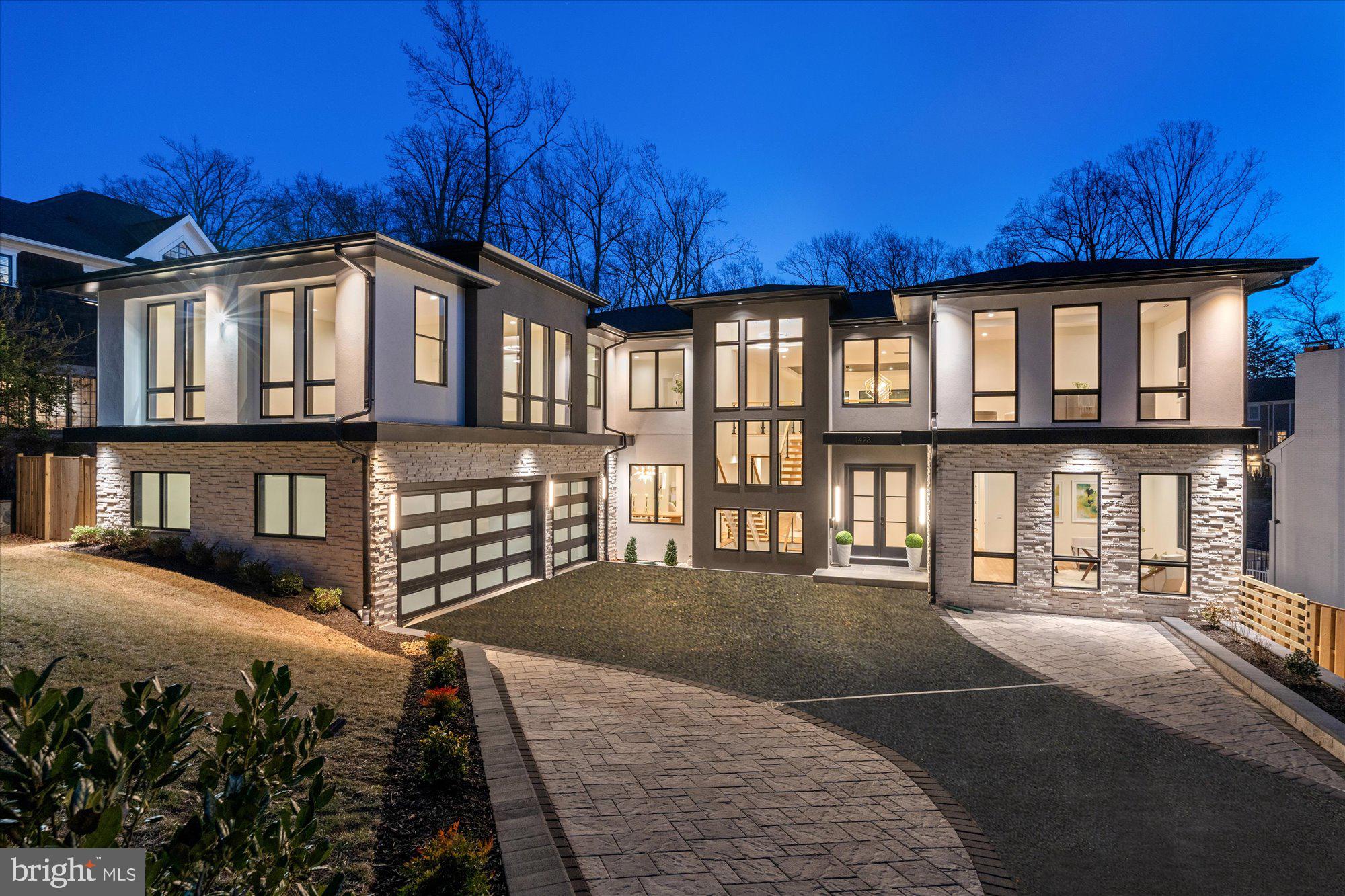 Offered at one of the most compelling values per square foot in McLean, 1428 Waggaman Circle presents a rare opportunity in the highly sought-after enclave of Salona Village—highly recognized for its close proximity to dining, shops, parks, and everyday conveniences. Designed by NVBIA award-winning Green Valley Custom Builders, this newly built estate spans over 10,000 square feet across three artfully curated levels.
A striking two-story foyer sets a sophisticated tone, anchored by a sculptural solid oak floating staircase with sleek glass railings. The gourmet kitchen is appointed with Thermador appliances, custom Conestoga inset cabinetry, quartz surfaces, a prep kitchen, and a walk-in pantry—all adjoining a morning room that overlooks a tranquil, wooded setting.
Purposefully designed for seamless indoor-outdoor living, this residence features a motorized screened-in porch and a spacious composite deck with ceiling-mounted heaters for year-round enjoyment. The upper-level primary suite is a refined retreat with a fireplace, private balcony, wet bar, and a spa-inspired bath boasting a freestanding tub, oversized shower, heated floors, and a TOTO bidet toilet.
Each secondary bedroom includes an en-suite bath and walk-in closet. The fully finished walkout lower level offers a media room, fitness studio, wet bar, and a newly added wellness retreat with an infrared sauna and steam shower. A covered terrace with an outdoor fireplace completes the home, framed by a lush, tree-lined backdrop.
Crafted with intention by Green Valley Custom Builders—known for their elevated design and enduring quality—this residence is a celebration of innovation, craftsmanship, and timeless elegance. Private tours now available by appointment.