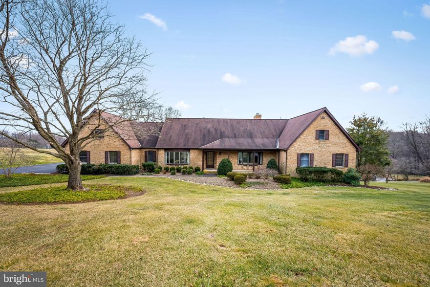 Tucked at the end of a quiet cul-de-sac, this expansive brick home offers a rare sense of space, privacy, and flexibility, set against a backdrop of rolling lawns and mature trees. Designed for both gathering and quiet moments, the main level flows beautifully from formal living spaces to more relaxed areas, including a large family room centered around a striking wood-burning stone fireplace and wet bar. An eat-in kitchen with breakfast area opens to the outdoors, while a dedicated office (or additional bedroom) , laundry room, and half bath add everyday ease.

The main-level primary suite is a true retreat, featuring an en suite bathroom and two walk-in closets, allowing for comfortable first-floor living while still leaving plenty of room for family and guests elsewhere in the home.

Upstairs, three generously sized bedrooms and two full baths provide privacy and flexibility, along with abundant storage throughout. The finished lower level expands the living space even further, offering a welcoming recreation area with a second fireplace and wet bar, an additional bedroom and full bath, and multiple bonus rooms ready to adapt as a gym, studio, hobby space, or future finished living areas. Whether hosting large gatherings or creating spaces tailored to your lifestyle, this level offers endless possibilities.

Outdoor living is just as inviting, with composite rear decks and a covered patio overlooking the landscaped yard and surrounding natural setting. Three separate heating and cooling zones ensure year-round comfort throughout the home. Located within a gated community and just steps from walking trails leading to Loch Raven Reservoir, this home offers a peaceful connection to nature while remaining close to everyday conveniences.