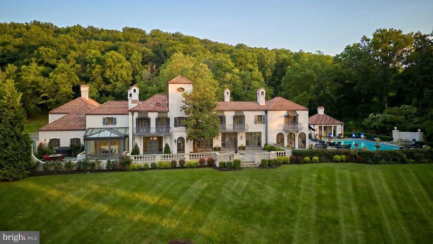 Where Old World romance meets the timeless beauty of New Hope, 3052 River Road stands as one of the Delaware Valley’s most exceptional waterfront estates. Originally designed by acclaimed architect William Lawrence Bottomley and comprehensively renovated in 2016, this 5,844-square-foot European-inspired villa is privately set on seven manicured acres. A rare find along the Delaware River, the property boasts 586 feet of pristine river frontage alongside additional private frontage on both sides of the historic canal.
A Belgian block driveway leads to a grand motor court and a striking three-tier fountain. Inside, the home blends grand proportions with intimate warmth, anchored by original 1920s parquet floors, rich oak flooring, and sweeping water views. The gracious living room features a built-in wet bar, while the formal dining room is illuminated by a custom Venetian chandelier. At the heart of the estate, the chef’s kitchen pairs premium granite countertops with two massive islands equipped with multiple sinks and dishwashers—a masterpiece designed for effortless, grand-scale entertaining. This exceptional hub flows into a dramatic glass conservatory overlooking the river.
An abundance of natural light fills the river room, where nine sets of French doors open to a private outdoor oasis. Here, you'll find a newly resurfaced, heated saltwater pool and spa, a pool house complete with a full bath, laundry, grill, and sauna, an outdoor shower, and a vine-covered pergola designed for al fresco dining.
The upper level offers two spacious ensuite bedrooms, a mahogany-paneled study, and a luxurious primary suite complete with a gas fireplace, Juliet balconies, a marble bath, and panoramic river views. Perfect for extended family or staff, a separate guest wing with its own private entrance offers two additional ensuite bedrooms. A three-car garage and a large side courtyard complete the estate buildings.
The grounds feature manicured hedges, vibrant gardens, and a secret artesian pond with a private dock. For the ultimate lifestyle convenience, take a scenic ten-minute stroll across the canal bridge and along the towpath into Stockton, NJ, for fine dining and the renowned Stockton Inn and Market. Located just minutes from the heart of New Hope and Lambertville, this estate offers a distinct financial advantage for out-of-state buyers looking to utilize Pennsylvania's highly favorable flat income tax structure. Furthermore, to accommodate an immediate and effortless transition, the home’s nearly-new, curated Restoration Hardware furnishings are available by separate negotiation.
Conveniently located 90 minutes from New York City, 60 minutes from Philadelphia, and 40 minutes from Princeton, 3052 River Road is a turn-key legacy estate of rare natural beauty, provenance, and permanence.