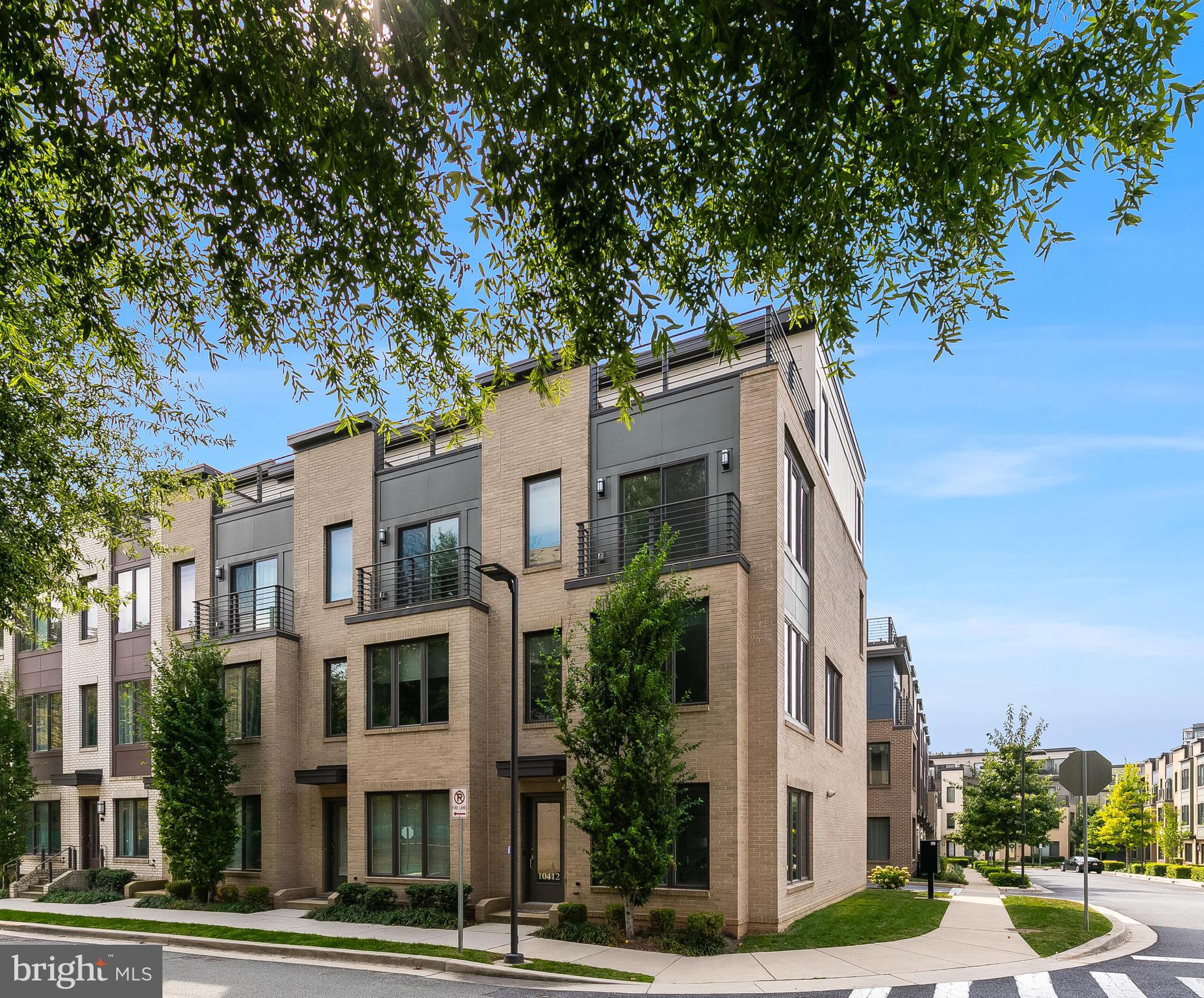 End Unit. Built in 2019 by EYA Homes, 4 bedrooms and 3.5 baths. This stunning four-level end-unit townhome in sought-after Montgomery Row offers over 2,100 sq. ft. of stylish living space. The home impresses with beautiful floors, soaring ceilings, expansive windows, and an open, light-filled layout.
The main level boasts a chef’s kitchen with quartz countertops, designer backsplash, oversized island with seating, and access to a private balcony. The kitchen flows seamlessly into the spacious dining and living areas, surrounded by walls of windows that bring in abundant natural light and showcase serene community views.
Upstairs, the second level includes two generously sized bedrooms and two full baths, including a sophisticated primary suite with a spa-like bath and walk-in closet. The top level features a third bedroom, full bath, large family room, and private rooftop deck—perfect for relaxing or entertaining.
Additional highlights include a two-car garage with storage, plus a bonus garage space across the street.
Ideally located between the Capital Beltway and I-270, commuting is a breeze. The home is tucked into a quiet neighborhood yet just minutes from Grosvenor Metro, Westfield Mall, Wildwood, and Pike & Rose—offering the perfect balance of tranquility and convenience. // 2 car garage, 1 on-street parking AND 1 pass for the office garage across the street. //