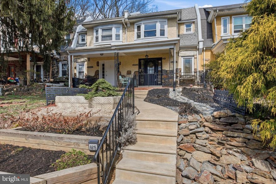 Welcome to 6615 Morris Park Road, a well-maintained 3-bedroom, 1.5-bath home with a beautifully landscaped front yard, tucked away on a quiet street in a convenient Philadelphia location. Enter through the cozy covered front porch into a spacious living room featuring original hardwood floors that continue into the dining area, creating a warm and inviting flow. The kitchen is open and functional with a quaint, charming feel, a tiled backsplash, and thoughtful updates over time, making it a comfortable space for everyday living. Upstairs, the primary bedroom is situated at the front of the home, welcoming in beautiful morning light. Two additional bedrooms are located at the rear of the home, one featuring detailed crown molding. All bedrooms offer original hardwood flooring, neutral finishes, and great natural light, along with a full ceramic tile hall bathroom. The partially finished basement provides additional flexible space, a convenient half bathroom, extensive storage, and direct access to the 1-car garage and rear parking. Over the years, the home has seen numerous upgrades including electrical improvements, a tankless water heater, updated windows, a rubber roof, and a variety of interior enhancements that blend modern convenience with its classic character. Outside, enjoy a surprisingly spacious outdoor area for a home of this style, surrounded by mature trees and a peaceful setting. Just steps from your front door is Morris Park, a 140+ acre wooded park with trails, wildlife, and open space, offering a rare connection to nature while still being close to the Main Line, Center City, and public transportation. This is a solid, comfortable home with charm, thoughtful updates, and an unbeatable location.