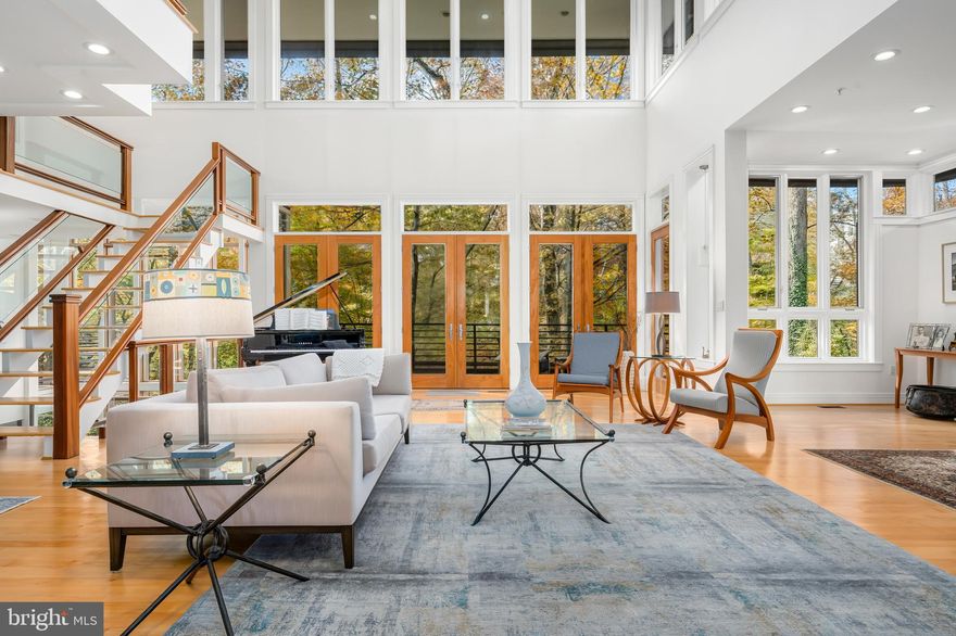 OPEN SUNDAY | MARCH 1st [1pm to 3pm]    ELEVATOR TO ALL LEVELS.  At the quiet end of a cul-de-sac bordering Rock Creek Park, this modern home seems to emerge from the landscape itself. From the front approach, its low roofline, horizontal brickwork, and natural materials convey a calm order, an urban reflection of the organic principles  advanced by Frank Lloyd Wright. The architecture feels timeless and assured, grounded in Washington’s built tradition yet oriented to the forest beyond. At the rear, the façade becomes a masterclass in the fusion of private residence and wooded landscape. Expanses of glass and carefully scaled terraces dissolve the boundary between structure and setting, allowing nature to animate the architecture throughout the day. Inside, the design by Travis Price, FAIA unfolds as a study in movement and light. A double-height great room anchors the plan, framed by floating landings and structural glass that draw natural light through every level. The arrangement creates a natural progression from open gathering spaces to quieter moments of retreat, each revealing a distinct relationship to the wooded setting. An elevator serves all levels, connecting spaces that were shaped to evolve gracefully over time. Rooms adapt in purpose and scale, a study or studio, a guest suite, a den that opens to a terrace, or a lower level designed for wellness and work. Throughout, materials remain honest and enduring, brick, glass, steel, and wood in balanced proportion. Every element serves the experience of living within architecture rather than beside it. The result is a home of enduring calm and presence, modern in spirit, profoundly connected to nature, and perfectly situated along one of the city’s most treasured park front settings.