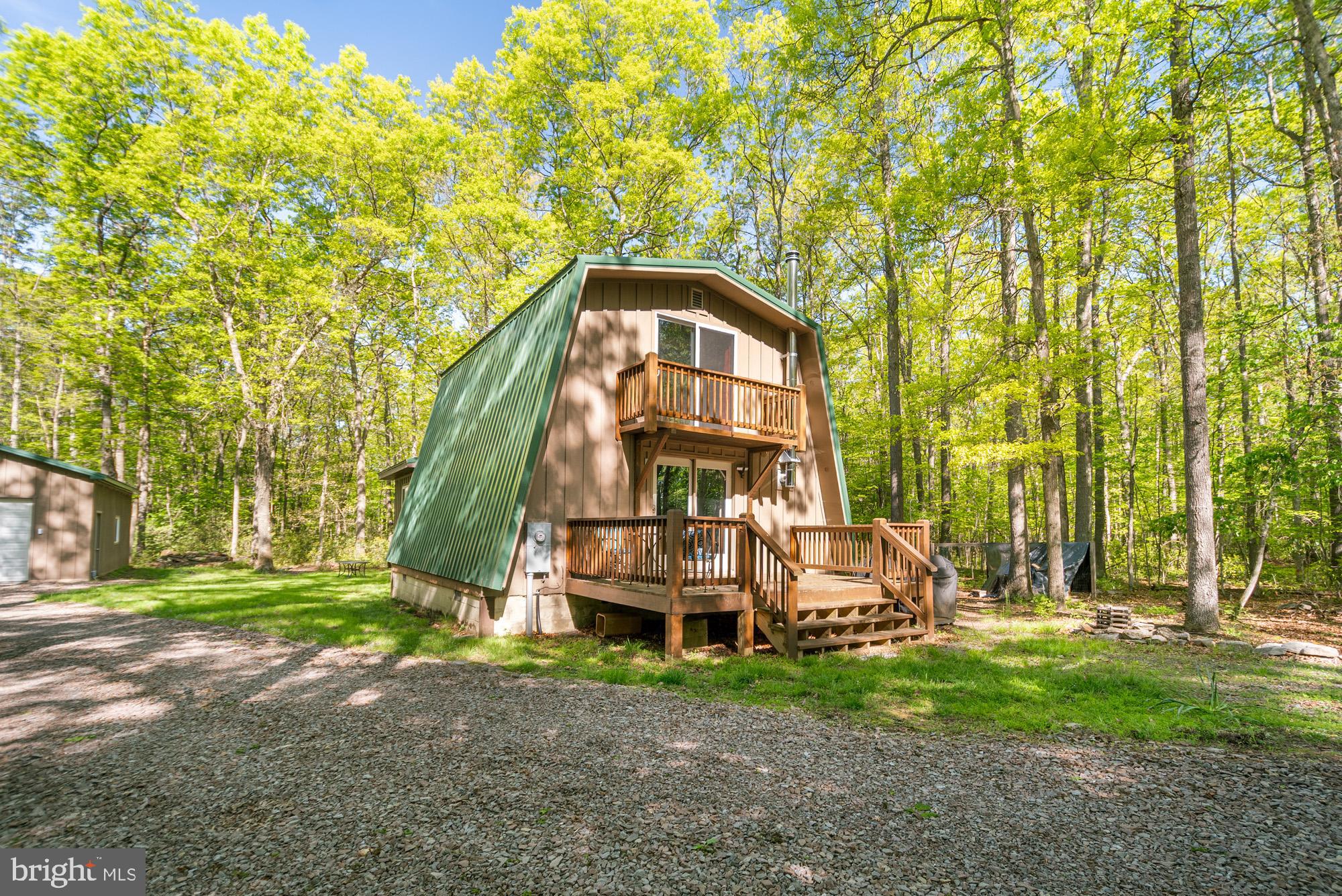 Tucked away on 1.42 acres across three wooded lots, this recently remodeled 3-bedroom, 2-bath home offers the perfect blend of comfort, character, and privacy. Step onto the expansive front deck, where mornings are made for sipping coffee and soaking in the peaceful surroundings. Inside, you'll find beautiful bamboo floors flowing through the open living, kitchen, and dining spaces—ideal for cozy nights in or hosting friends. A warm wood stove adds extra charm and comfort, creating the perfect spot to gather on chilly mountain evenings. The main-level primary suite features soft new carpet, a rustic barn wood door, and direct access to the back porch. Just beyond, the hot tub sits privately, offering a relaxing retreat under the stars. Upstairs, two additional bedrooms and a full bath provide space for family and guests—one even has its own private balcony, perfect for a quiet escape. This home is sold furnished, with the exception of the master bed and dining table, making it easy to move right in. The brand-new 24x32 detached garage offers tons of storage space and room for your vehicles, toys, or workshop. With plenty of parking and a serene mountain setting, this is a true getaway. Located within the gated recreation community of Yough Mountain Resort, you'll have access to over 50 miles of ATV, snowmobile, and hiking trails, as well as river access, fishing, and hunting opportunities. For those seeking even more adventure, Deep Creek Lake, the town of Oakland, Swallow Falls, and Herrington Manor State Park are just minutes away, offering endless possibilities. Call today!