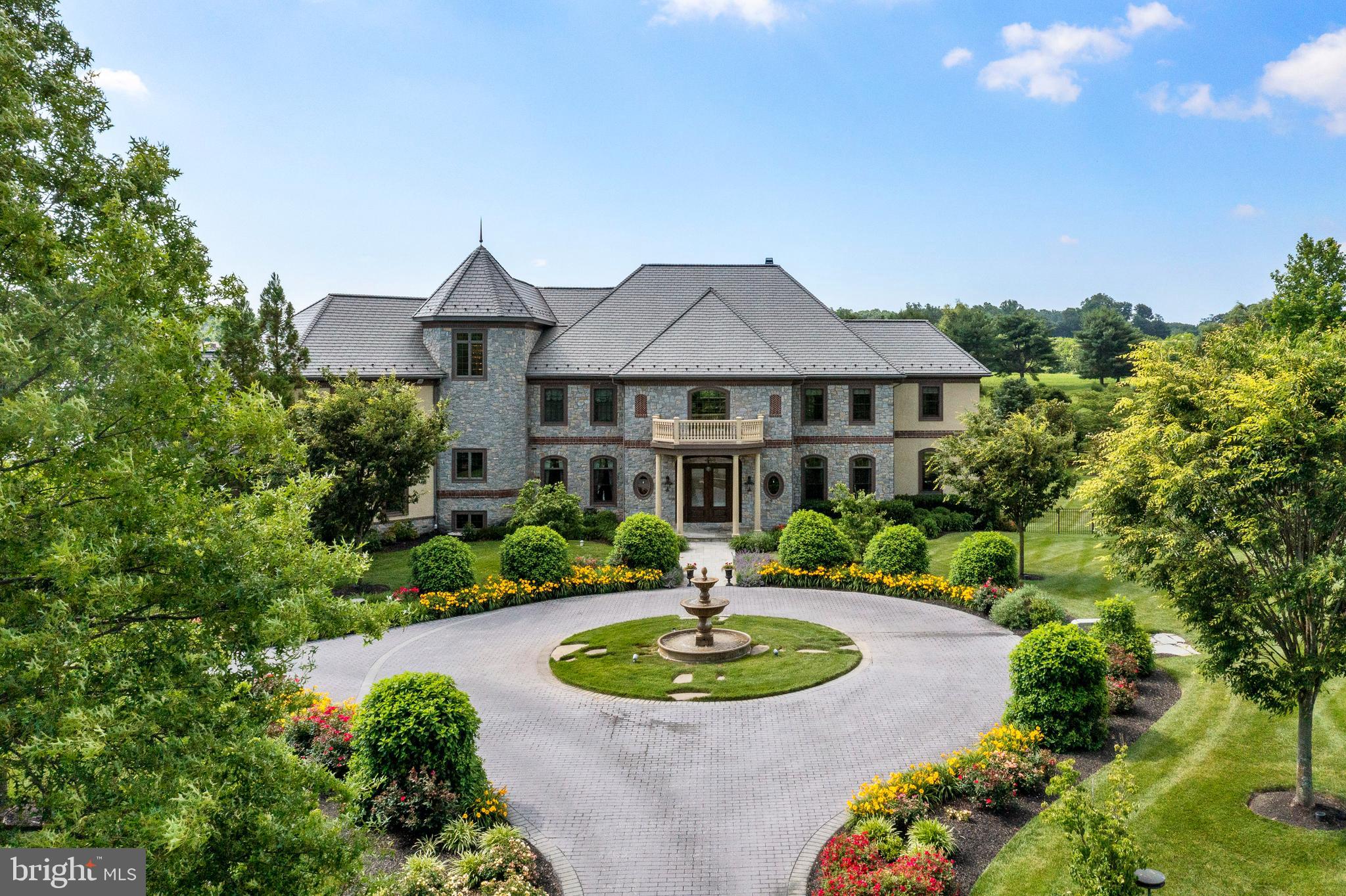 Welcome home to this immaculately designed, one of a kind custom-built Malvern estate. Located in the heart of Willistown, this unique home is a perfect coalescence of resort style amenities, intelligent smart home features, and convenience. Upon arrival you will see a circular driveway with a water fountain. The impeccable landscaping designed by a traditionally trained Longwood Gardens botanical architect encircles the entire property and offers a bouquet of fresh scents and colors throughout the seasons. There is an incredible beauty on the property grounds that consists of a truly luxurious oasis, complete with an Intellichlor hybrid salt/chlorine pool, hideaway spa, blended waterfall and fire features, koi ponds, serenity gardens, professionally lit tennis court, climate controlled pool house, a large stone patio deck with Viking outdoor kitchen, and so much more! You will enter the home through the stately French doors that open up to a grand foyer with over twenty-two-foot ceilings and a striking double staircase. In the foyer you will see a custom illuminated inlay with hidden electrical outlet allowing second floor lighting with no cord exposure. Architectural light consultants ensured every room of the home has a perfect blend of natural and artificial light as well as sweeping views of the landscape. The grand living room boasts floor to ceiling windows, a gas fireplace, and offers lavish views of the backyard and an open floor plan. The impressive gourmet kitchen is adorned with Miele and Wolf appliances, and additional features you may not notice such as: coffee station, warming oven, custom wine refrigerator, etc. There is a large panoramic breakfast room that has controllable blinds that change the amount of natural light coming into the home. The floor plan is open and consists of an impressive family room with double fireplace, a bonus room, executive office, two powder rooms, formal living room, formal dining room, mudroom with custom cabinetry, butler’s pantry, wet-bar area, and access to the rear patio.
The balcony upstairs overlooks the massive family room and grand foyer. Barrel ceiling and ropes lighting lead to the bright and spacious primary suite, complete with a fireplace, custom owner’s closet boasting impressive dressing island, frosted cabinetry, window seating, and vanity. The primary bathroom has Robern hideaway cabinets, aromatherapy spa-tub, heated floors/towel racks, anti-fog shower mirrors, intelligent lighting, and more. There are 3 additional bedrooms as you walk down the corridor, all with full bathrooms. There is a second-floor laundry room, equipped with marble counters and Miele washer and dryer. At the end sits an impressive junior suite with fireplace, heated floors, and large walk-in closet. A breathtaking chandelier can be seen at the top of the outdoor turret and is equipped with a winch to lower to the first floor for ease of cleaning. At the top of the fourth floor is an oversized cedar closet for storage, as well as an approximate two thousand square feet of space that can be finished. Upon descending the impressive staircase, you will come upon the lowest level that was built for entertainment. Here you will find a custom bar with counter seating, a 1,200 bottle temperature-controlled wine cellar, movie viewing area, fitness room, Finnish sauna, full bathroom, billiards area, second laundry room, tanning room, and the home’s SmartHub. The walkout basement leads you to the slate covered patio that overlooks the entire pool area and backyard space. Every single facet of the home is controlled through easy-to-use smart home technology. Every room in the house has a control panel that commands everything from lighting, to blinds, to music, to television inputs and the entire home can be controlled from a smartphone or tablet. The well thought out features of the home are too many to list and this masterpiece is something that mustbe seen in person!