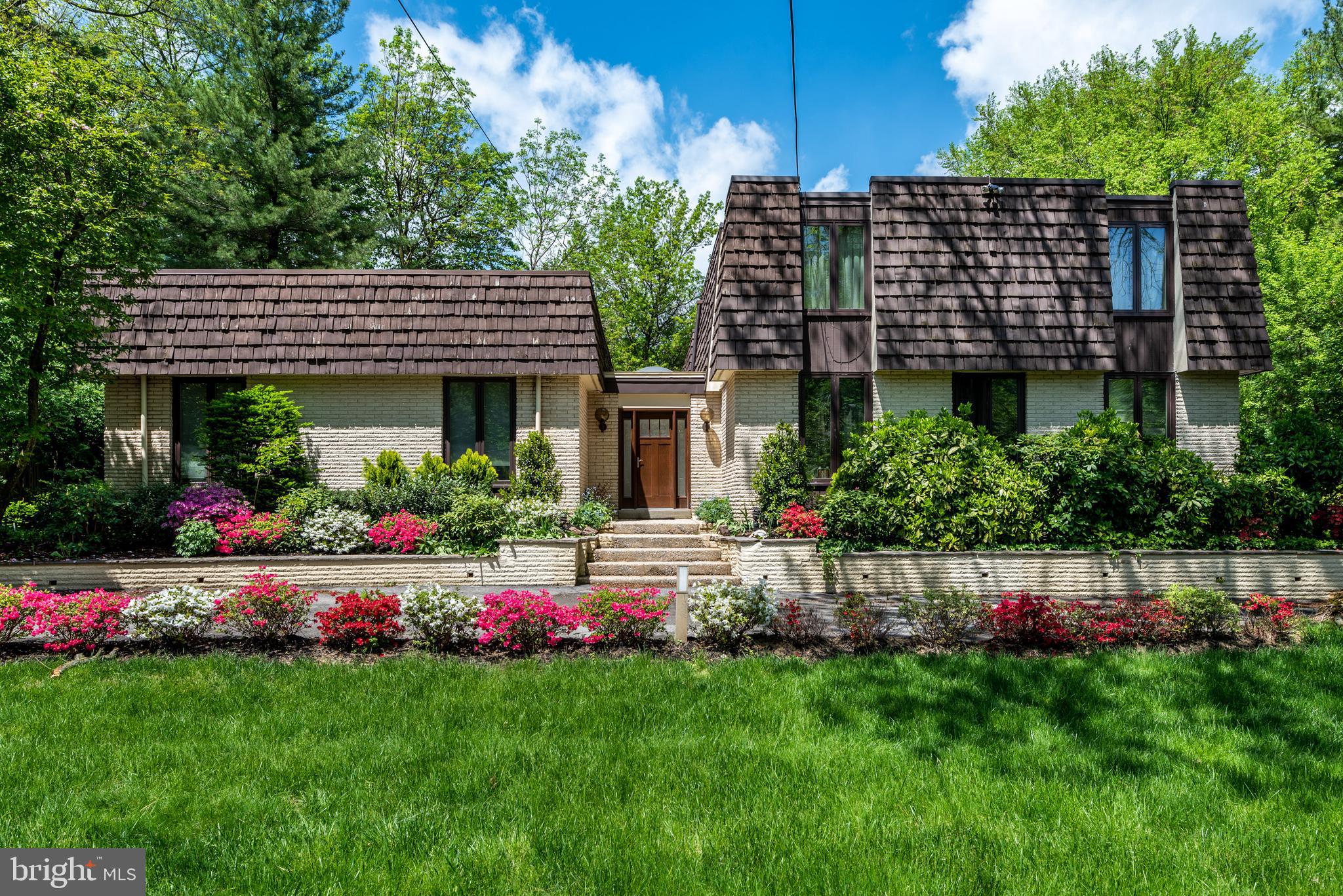 This sleek, contemporary home, surrounded by a beautiful yard, patio, and gorgeous pool, also boasts an unbeatable location in Lower Merion. With a circular driveway and beautiful plantings, the entry to the home is memorable. When you step inside, you will sense the uniqueness of the property, with its arresting, all-glass front staircase and tiled entryway. The sunny living room has pocket doors leading into the family room, with hardwood flooring and beautiful wood-paneled walls. Glass sliders aid the flow into a bright sunroom that opens onto the generous patio and pool area. The outstanding kitchen is a chefs delight, with numerous amenities. The sophisticated chef will love the two Wolf ovens, warming drawer, Sub-Zero refrigerator, and double sink. A beautiful center island features an additional sink, 5+ burner gas cooktop, and bar seating. The open breakfast room is ideal for entertaining, featuring an additional bar area with wine and beverage fridges, as well as glass sliders to the patio. Enjoy formal occasions in the separate dining room with a built-in buffet table. A convenient mudroom offers main floor laundry, an informal powder room, two closets, and access to the attached two-car garage, driveway, and basement. There is also a formal powder room off the foyer, which is ideal for guests. A cozy office/den off the kitchen and dining room complete the main floor. The glass staircase leads to the second floor, with two large hall closets. The main bedroom features large walk-in closets and a sitting area. The main bathroom is luxurious, with its soaking tub, walk-in shower, and oversized vanity. The second level has three additional bedrooms, a home office, and two renovated hall bathrooms. The partially finished lower level has a recreation room, cedar closet, and lots of storage space. The walkability of this neighborhood is notable: easily stroll to Narberth, Suburban Square, and Arnold Field. Enjoy perfect summer days poolside, and cozy fall nights on the patio. Though the setting is private, the home is close to public transportation, including regional rail and bus service to Center City.