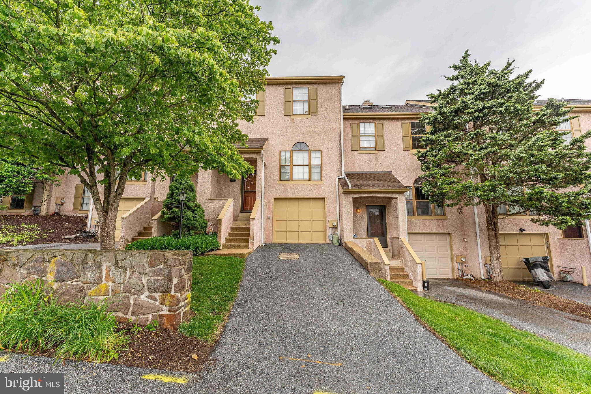 Welcome to 3205 Stoneham Drive — a beautifully maintained 3-bedroom, 2.5-bath townhome nestled in the desirable Willistown Woods community of West Chester. This charming home offers the convenience of a 1-car garage and private driveway. Step inside to a bright two-story foyer featuring hardwood floors, a graceful chandelier, a coat closet, and a welcoming staircase. Follow up the stairs to a convenient powder room with vinyl flooring, semi-vaulted ceilings, and a safety grab bar. The kitchen boasts hardwood floors, granite countertops, and a sunny front-facing window, perfect for morning light. A half wall opens to the dining room, where you’ll find more hardwood flooring, a lovely chandelier, and a double-sided wood-burning fireplace that also warms the adjoining living room. The spacious living area features hardwood floors, a large double window overlooking the backyard, and sliding glass doors that leads to a private patio—complete with a retractable awning for shaded outdoor enjoyment. Upstairs, the primary bedroom offers comfort and style with plush carpet, crown molding, and dual closets. The en-suite bathroom features tile flooring, crown molding, dual vanities, and a tiled tub/shower combo. A second bedroom on this level, also carpeted, is ideal for guests, children, or a home office. The hall bath includes a single sink vanity and a tiled tub/shower combo. The third floor hosts a versatile loft space with carpet, a ceiling fan with light, and two skylights—perfect for use as a third bedroom, office, or creative retreat. The partially finished basement adds even more functional space, including a carpeted bonus room, walk-in closet under the stairs, laundry area with washer and dryer, utility room, and access to the garage. Enjoy all this in a fantastic location close to local restaurants, a Giant supermarket, Wawa, and more. Don’t miss your opportunity to make this wonderful townhome your own!