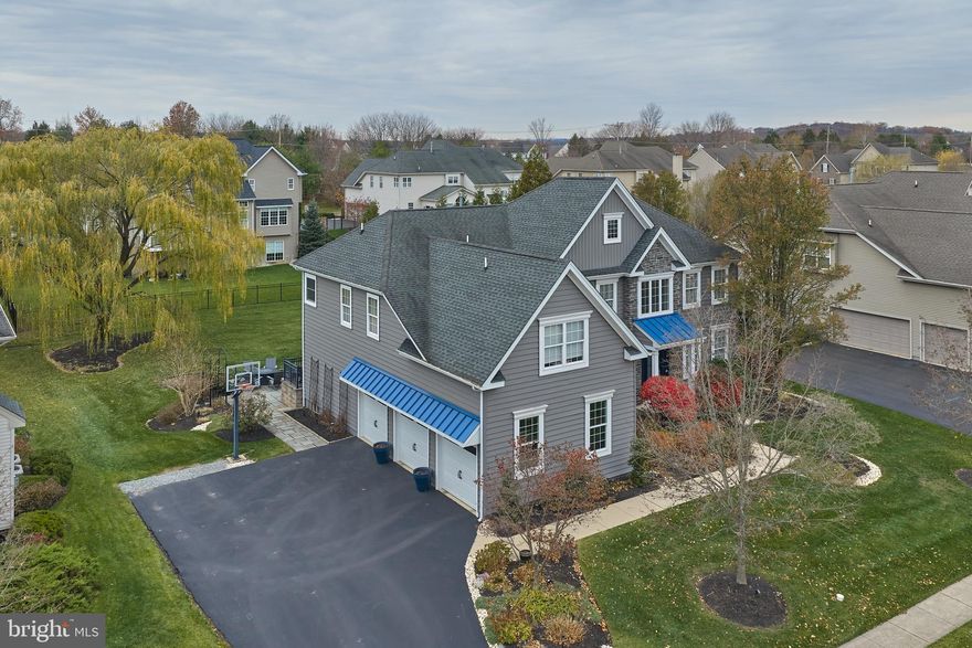 Welcome to a life of refined comfort at 2080 Bedfordshire Road nestled within the prestigious Devonshire Estates community. This is the definitive setting for your next chapter, offering an exceptional blend of elegance, security, and superior amenities. The moment you arrive, the uncompromising quality is evident; from the striking blue metal roof accents, to the elegant front door with privacy glass, to the newly installed, insulated siding with artisan stone accents - style and design coupled with superior energy efficiency.Inside, the freshly painted interior showcases a seamless transitional design with new flooring, designer lighting, and custom blinds. The formal living and dining rooms boast custom millwork (crown molding and wainscoting), providing a sophisticated backdrop for entertaining. The large family room, framed by an elegant arched entryway, features built-in bookcases and an impressive floor-to-ceiling gas fireplace with custom stone surround—a true focal point for cozy evenings and memorable  conversations.The well-appointed kitchen features an oversized island and professional-grade appliances including new refrigerator, double oven, and microwave. The sun-drenched breakfast room, with rustic wood beams and expansive windows, overlooks the lush backyard and picturesque weeping willow tree. A flexible sitting room/office, laundry room, and powder room complete the main floor. The private back staircase leads to the upper level, offering a quiet retreat. A beautiful loft with arched columns overlooks the family room to create a serene family gathering spot.  The Owner's Suite is an unparalleled sanctuary featuring an expansive sitting area, dual walk-in closets, an additional, dedicated flex room—ideal for a home office or nursery; and a ‘secret’ craft room. The primary bath has been gorgeously remodeled with rich natural stone, a custom walk-in shower, built-in shelving, and a luxury bidet toilet. The second bedroom offers an ensuite junior bath, while two additional spacious bedrooms share a well-appointed hall bath.The finished, walk-out lower level is designed for flexible multi-generational living and group gatherings, including an expansive entertainment/media room, a private guest suite, a full bathroom, and a custom bar area alongside a dedicated kitchenette.  A large unfinished storage area offers space for all the extras.The investment in this home's infrastructure offers unrivaled peace of mind with recent major upgrades, including two brand new high-efficiency HVAC units and the crucial whole-house generator. Additional curb appeal is added by three new garage doors with awnings and lighting, and many new windows throughout. Outside, the two-level bluestone patio offers both a cozy niche and ample outdoor entertainment space to enjoy the meticulous, thoughtfully designed landscaping. There is a tot lot, walking trail and  3 gazebo parks in this unique neighborhood. This exceptional residence is located within the nationally-recognized, award-winning Central Bucks School District. Its prime location offers the rare convergence of country charm and urban accessibility—just minutes from the upscale dining, shopping, and cultural attractions of Doylestown, Newtown, and historic New Hope.