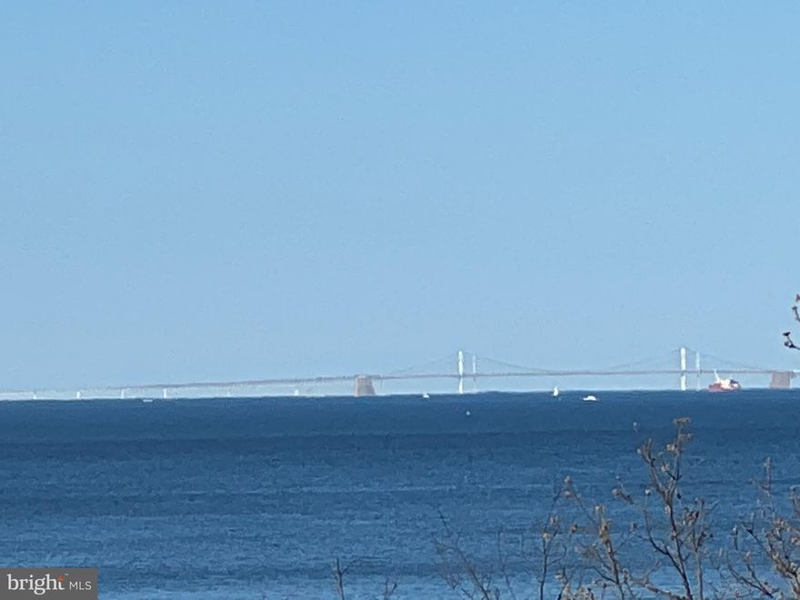 BE SURE TO WATCH THE VIDEO TOUR -- SHOT WITH A DRONE! GORGEOUS! NEW PRICE!   Where else can you enjoy $2 MILLION $ DOLLAR $ VIEWS $ of the CHESAPEAKE BAY for this price!!!? You won't want to leave!  No additional expenses for maintaining a dock or a sea wall, and just relax &  enjoy this beautiful home with Bay breezes  & SPECTACULAR views!!!  IMAGINE waking up every morning to BAY BREEZES & 180 degree views of the Chesapeake Bay!  Eagles soaring, Ospreys building nests, TOTAL PEACE & TRANQUILITY on nearly 2 acres of land! Don't miss our virtual tours (drone videos!!!)  Swaying reeds in the private marsh, watching the ships/boats sail past, and also overlooking the gorgeous Jack Creek Park ! So much OUTDOOR space! Double glass entry doors lead you into a large foyer with CATHEDRAL CEILINGS opening to a HUGE great room, with a gas fireplace,  separate dining room,  covered porch/balcony,  and also sliding glass doors that open to a glass enclosed porch/sun room with walls of casement windows) showcasing unbelievable water & nature views.  Step outside onto the EXPANSIVE Trex deck  (2013) for more views & breezes, with stairs down to yard. From this ENCLOSED porch , you can enjoy your morning coffee, entertain, or relax for an evening glass of wine! AND a total of 4 decks/covered porches and OVER 3,000 SF of finished living space. TOTALLY OPEN concept home with soaring ceilings and Bay views from virtually every window!  A spacious, RENOVATED eat-in kitchen with incredible views -- ideal for entertaining or spoiling your family & friends for home-cooked meals, special occasions, and more!  Granite counter tops, glass tile backsplash, stainless appliances, and a breakfast bar offering even more counter space, 42" re-faced white cabinets, PLUS a fantastic pantry!  Elegant powder room right off the kitchen with porthole-style window & pedestal sink.   Upper level boasts an Owner's suite that will NOT disappoint -- HUGE bedroom with sitting room,  large windows (& Bay views, of course), multiple closets & a large walk-in closet, spacious RENOVATED luxurious spa-like bath with marble counter tops on  modern dual vanity, chrome fixtures, over-sized, frameless glass enclosed tiled shower, luxury vinyl plank flooring & palladium style window.  To top it all off, your laundry room is conveniently located in a dedicated room right off the Owner's suite! ... WOW!  AND access to a large, private balcony overlooking DREAMY scenic views of Chesapeake Bay and undeveloped marsh area!  Walk-out lower level is partially finished with large in-law suite, to include great room, kitchenette, full bath (with additional washer) and doors leading to expansive covered patio.  TONS of storage space throughout basement and room to create more finished living space.  Enormous lot lined with trees & views of the Bay!  Large 2-car garage & over-sized parking pad (fitting 6+ cars) You won't want to leave! All this and a generator, and new 50-year architectural shingle roof (2020).  Although this home does not have riparian right, there is a free public boat ramp within one mile, or you can keep your boat at one of dozens of local marinas or join the super popular Chesapeake Yacht Club with new floating docks!