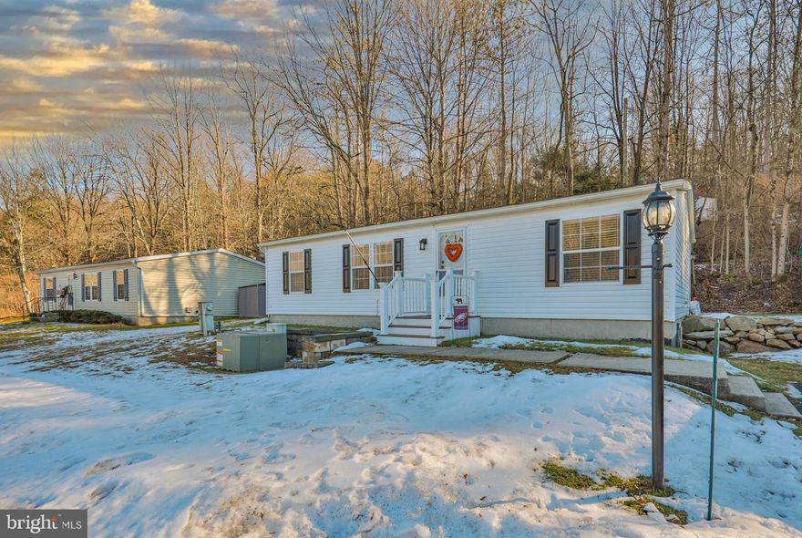 NOTHING TO DO BUT MOVE INTO THIS NEWLY RENOVATED 3-BR, 2-BA 2000 Fleetwood (1,056 sq. ft) ranch home located in the (55+ and older) community of Blue Mountain Village. You'll love the open floor plan allowing you to move freely throughout the home. RECENTLY RENOVATED! NEW Roof, NEW Central Air, NEW Propane Furnace, NEW Hot Water Heater, freshly painted rooms, NEW laminate flooring, NEW vanities, NEW faucets, NEW ceiling fans, just to name a few of the recent improvements! The ultra modern NEW kitchen features new cabinetry, countertops, tile backsplash, stainless appliances and with a center island that seats 2! The rear patio backs up to the woods for privacy! A detached shed and off street parking for 2+ cars! Blue Mountain Village is a 55+ retirement community. Monthly lot rent of $700 includes W/S, community club house with kitchen for hosting parties & family gatherings, gym & billiard club. Community surrounds a 9 acre catch and release lake. With the exception of the primary bedroom, living room TV and stand home being sold "FURNISHED"! This home is perfect as a main residence or your private getaway. BUYERS: Please make sure your approved for manufactured home financing . . VA, FHA, USDA or Conventional mortgages will not qualify for these homes. Looking to downsize? This is the Perfect Home! Call Today!