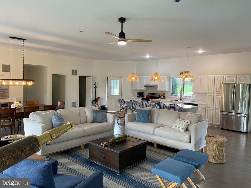 BACK ON THE MARKET AFTER A SHORT WINTER BREAK!
A rare opportunity to own a beautifully curated, income-producing retreat along the South Branch of the Potomac River. Set just steps from the water’s edge, this fully furnished riverfront home offers the perfect blend of modern comfort and the untamed beauty that defines West Virginia.
Currently operating as a successful short-term rental, the property is completely turn-key—ideal as a continued investment, a private getaway, or a thoughtful combination of both.
Inside, the home opens into a spacious and inviting layout with 4 bedrooms and 3.5 bathrooms. The main living area—where the kitchen, dining, and living spaces come together—captures sweeping views of the river from nearly every angle. A fully equipped kitchen and fast, reliable Wi-Fi make the home equally suited for relaxing weekends or remote work with a view. The lower level adds flexibility with a dedicated laundry room and a versatile fourth bedroom that doubles as a cozy playroom and TV lounge, complete with two sets of bunk beds—perfect for hosting family and guests. Outdoor living is just as memorable. Expansive decks on both levels overlook the flowing river, creating spaces for morning coffee, evening meals, and long summer afternoons. Enjoy outdoor dining with a grill and shade, unwind in the hot tub, rinse off in the seasonal outdoor shower, or gather around the fire pit as the stars come out over the water. Whether you’re expanding your short-term rental portfolio or searching for a one-of-a-kind riverside escape, this property delivers comfort, charm, and proven rental appeal. Just minutes from Moorefield, WV for groceries, dining, and everyday conveniences—yet it feels worlds away. **Airbnb listing available in Agent Remarks.