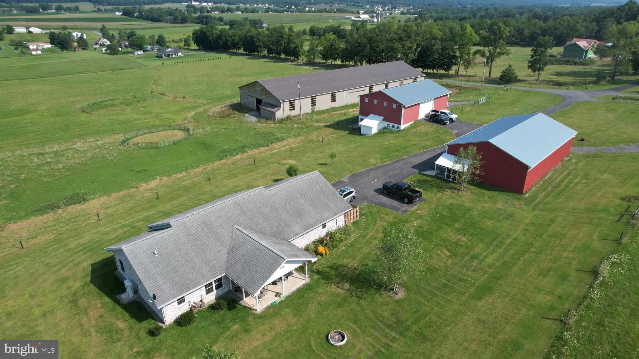 One of a kind Equestrian Facility in the Bellefonte School District with a 1926 sq ft stone Ranch Home, on 31.88 acres. Acreage is largely pasture (29 acres) with dark forest and ridings paths in the Mountain at rear. All roads and Farm Buildings are connected by paved surfaces. (Property also listed as Residential, see MLS#PACE2511462).
The home is a spacious Ranch positioned with a view of the surrounding mountains and greenery. All stone exterior with updated kitchen, granite counters, and stainless appliances. All rooms have new LTV hardwood flooring and walls and ceilings are hardwood tongue and groove paneling. With 3-bedrooms, 2-full baths open-style kitchen, dining and living areas that lead to and new a gorgeous rear patio and front porch. Comfort and security are provided by a new (2022) HVAC system and 2-car attached residential garage. Size is 1962 square feet.
A prominent feature on the property is a 40 x 50 Bank Barn (circa 1901), with (4) walk-out rear stalls that open to run-out fields, and tack room. All heavy-duty wood beam underpinning has been replaced and new metal roof completes the Barn exterior. The heavy-duty Barn floor has trap doors to drop feed and bedding into the stalls. Full electric service and multi delivery point water to each stall and clean-out points. The long-term love and care for this Barn (since 1901) provides a very large, dry storehouse for on-site grown Hay and Crop Storage.
A 72 x 40 Pole Barn Implement Garage has (4) wide bays with 15-foot clear-span for Combine or RV Storage. High-clearance overhead Doors are insulated with 12 foot clearance. Electric and water are provided to this building as well. Positioned inside this building is a home and all-facility Generac Emergency Generator.
New construction (2022) is a Regulation Size Dressage Riding Arena (200 x 70) with natural light windows bright arena lights. Drive in end doors, granular riding surface and a high tech overhead Water Arena manifold Dust Reduction System (all electronic with timers) provides for year-round riding and training. Large flat space adjoining to the Arena is dedicated space for Horse Trucks, Trailers and RV’s to visit for shows.