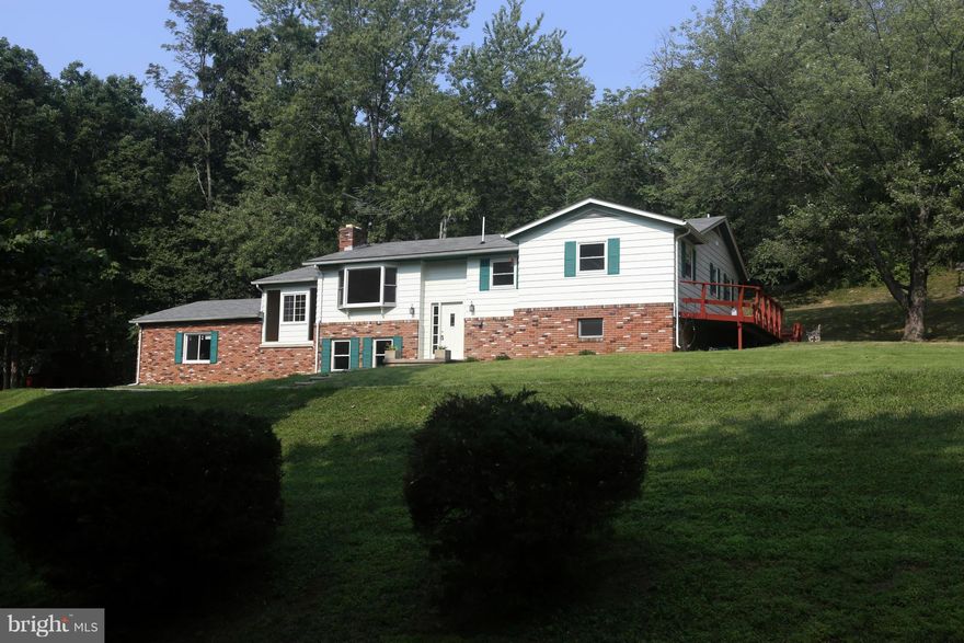 Priced for quick sale!! Retreat to this charming 2-story gem on 1.8-Acre wooded hilltop lot;  looped driveway, Huge wrap around deck, breathtaking views.  SOLIDLY build & ENTIRELY renovated in 2014 w/ Granite c-tops, SS appliances and HW floor! Lower level w/ spacious family room, fireplace, 4th bedroom, sep. laundry, workshop, cedar closet, full bath. Bright Breezeway/Sun room combo. New HVAC.