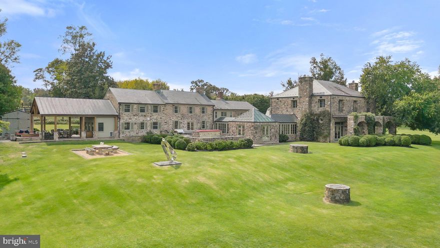 Littleton Farm comprises over 153 spectacular acres with a serene four-acre lake, two smaller ponds and Beaverdam Creek meandering through the property. Tucked in the southwest corner of Loudoun County and situated at the foothills of the Blue Ridge Mountains the property offers spectacular views. Considered the heart of horse and hunt country, this estate is situated within the famed Piedmont Hunt territory and provides tremendous ride-out. Anchoring the farm is the over 14,000 square foot French country fieldstone residence which presents comfortable living and entertaining spaces with soaring ceilings, unique and inviting gathering areas and breathtaking views of the lake and rolling hills. The oldest part of the home is believed to be well over 50 years old, but in the year 2000 a tremendous addition designed by well-known local architect Errol Adels was added. For the car enthusiasts there two detached garages with 4 and 6-bays.  Within the main home are 7 bedrooms, 6 full bathrooms, and 2 half baths. Upon entry, you are welcomed into the incredible living room with 14 foot ceilings with exposed wood beams, two fireplaces with limestone hearths imported from France and large tile limestone floors.  Three French doors open to a flagstone terrace with views of the lake and the impeccable grounds. From the living room, one can enter the guest wing or the main living wing through sun-drenched hallways. The guest wing offers 3 bedrooms and 2 full baths. The main living wing of the home was the original stone farmhouse and includes a cozy wood paneled library with a fireplace, a formal dining room, a commercial-grade kitchen with a breakfast area and the mudroom/pantry. Directly above the dining and kitchen area are the laundry room and two guest bedroom suites with their own full bathrooms. Above the library is a separate set of stairs to a one bedroom guest suite with a full bath. Relax and unwind in the primary suite showcasing sweeping views from two sets of French doors and numerous windows. Located above the large living room, this private space provides all the luxuries expected in a primary suite – a sitting area, fireplace, separate walk-in closet with ample built-ins, full bathroom with dual vanities, separate soaking tub and standing shower, as well as a home office. To complete the house, family and friends will love the extravagant family room and home theater located on the finished lower level. From a separate outside entrance one can access the over 2000+ bottle wine cellar. A few hundred feet from the main home is the 60-foot salt water pool and a pool house complete with a steam room, large gym, guest bedroom and full bath. There are two additional guest suites with their own full bathrooms and separate entrances located above the 4-bay car garage near the pool house.  Other farm outbuildings include: 2 horse barns (12 stall barn and 17 stall barn), 1 machine shed, 4 run-in sheds, a 100 x 200 riding arena, 3 and 4 board fenced pastures with Nelson automatic waterers. The property is protected by a VOF open space easement. Littleton Farm is conveniently located 38 miles from Washington Dulles International Airport and 52 miles from our nation's capital. Be sure to watch the video!