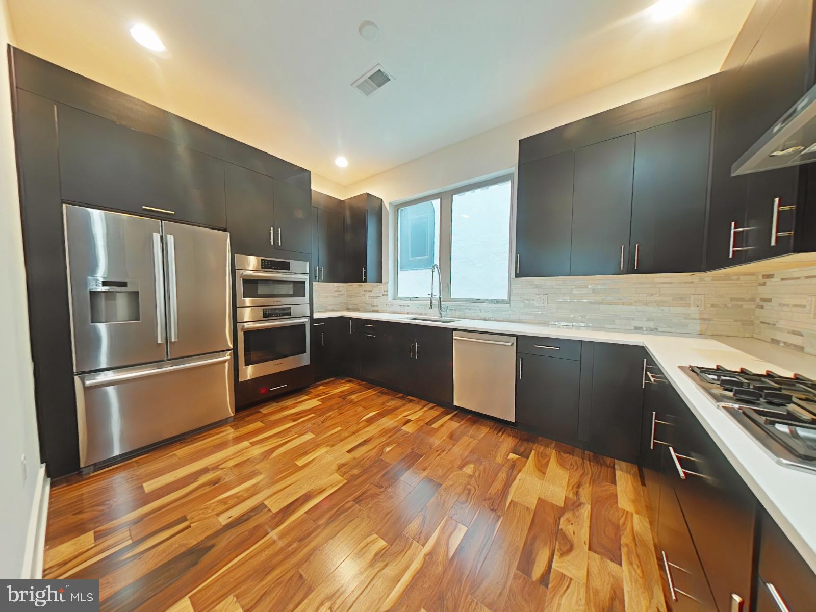Welcome to luxury living in the heart of Philadelphia’s historic Old City! This stunning townhome combines high-end finishes, spacious interiors, and unbeatable city access — all in a private, community setting. Enter through a tucked-away driveway and step into your private oasis in the city, complete with a 1-car garage for easy, private parking. The first floor opens to a light-filled sitting room with gleaming hardwood floors and oversized sliding glass doors that lead to a fully fenced-in backyard patio — perfect for relaxing, entertaining, or hosting summer gatherings. Head upstairs to the gourmet kitchen, a chef’s dream, featuring top of the line stainless steel appliances, elegant cabinetry, and tons of countertop space. Flooded with natural light from oversized windows, the kitchen flows seamlessly into a spacious dining/living area accented by recessed lighting, even more hardwood floors, and a cozy reading alcove. A stylish powder room completes the main living level. The third floor offers two spacious bedrooms, a large full bathroom, and ample closet space — all bathed in natural sunlight thanks to the large windows. At the top level, you'll find a luxurious primary suite with a walk-in closet, recessed lighting, and an elegant en-suite bath that includes a dual vanity, sleek tile finishes, and a spa-inspired glass shower with multiple shower heads and a rainfall feature. And yes — the best is saved for last. The private rooftop deck offers jaw-dropping views of the Ben Franklin Bridge and comes complete with built-in cabinetry and an outdoor refrigerator, making it ideal for entertaining under the stars.
13-month HWA home warranty will be included with acceptable offer. This must be included in the Agreement of Sale.
With a Walk Score of 89, you'll find that most daily errands can be completed without a car, everything you need is just around the corner. A Transit Score of 94 means public transportation is highly efficient and convenient. The Bike Score of 89 reflects a strong biking infrastructure.
Enjoy being just minutes from local favorites like Paddy’s Old City Pub, Torch-Wood Market, and Waterfront Gourmet Café & Deli — plus many other great dining and shopping spots. Grocery options are plentiful too, with Riverwards Produce Market, Mulberry Market, and others nearby.
For families, highly regarded schools such as General George A. McCall School and Benjamin Franklin High School are close to home. You're also only six minutes from the 2nd Street Station on the Market–Frankford Line, making your daily commute fast and simple.
Take advantage of nearby outdoor destinations like Independence National Historic Park, Welcome Park, and Franklin Square — perfect for enjoying fresh air, history, and community events.
This home offers unbeatable access to all that Old City has to offer. Tax abatement in place through January 2027.