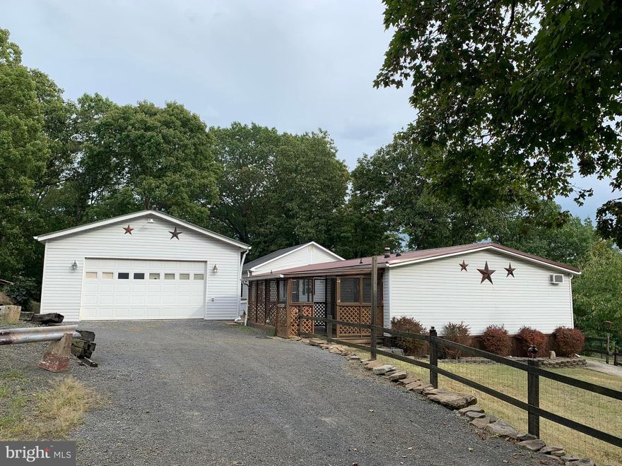 Looking for space and one level living in a quiet, peaceful setting? Look no further! This double wide mobile home with HUGE addition sits on a permanent foundation and is situated on an acre of secluded land. It offers four large bedrooms with walk-in closets and storage shelves in each. Two full bathrooms have been updated, one of which is the en-suite bathroom with a soaking tub and separate shower. New vinyl plank flooring has been installed in both bathrooms as well as the kitchen. The kitchen has newer appliances and offers plenty of space for storage. This home also offers two living room areas, perfect for making new family memories as well as a bonus room that could be used as office space. A huge attic and partial 425 sq ft unfinished basement area provides for more storage and leaves room for potential customization. Outside of the home you will find two covered porches that are perfect for relaxation and a fenced-in side yard that is accessible from the front or back doors. A brick patio with fire pit and outdoor fireplace are a great spot to host outdoor gatherings. You’ll also find the detached 24x24 two car garage with a tool room and full attic. The garage is equipped with heat and electricity. Towards the back of the lot is an extra storage shed, perfect space for lawn equipment. There are many updates and improvements throughout. The newer metal roof is just four years old, and the well and water filtration system, along with the hot water tank were replaced in the fall of 2021. This home combines functionality, comfort, and natural beauty, making it an ideal place to call home! Don’t miss out on the opportunity to make it yours!