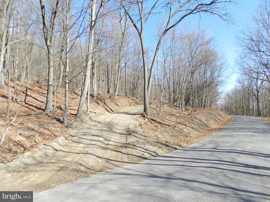 18.87 acres ready to build within a mile to Green Ridge State Forest! Escape to 18.87 acres of peaceful bliss, just one mile from Green Ridge State Forest—Maryland’s largest contiguous public land offering 49,000 acres of prime hunting, fishing, trapping, hiking, and outdoor recreation. This outdoor enthusiast’s paradise offers the perfect blend of privacy and accessibility. This property consists of two parcels and is ready for your dream home or kept as raw land for hunting and recreation. Featuring county-maintained road frontage, it has already been perced for a 4-bedroom home, with a gravel driveway, culverts, and drainage in place. This property is primed for residential construction with a cleared and graded pad site waiting for your vision, ensuring low site development costs.  
The land provides the scenic, mountainous landscape that nature lovers appreciate. Plus, it’s safely located outside the 100- and 500-year floodplains, adding peace of mind to your investment.