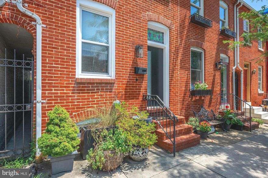 Welcome to 419 S Ann Street — a thoughtfully renovated and impeccably maintained residence located in the heart of historic Fells Point. Ideally situated just steps from the waterfront, award-winning dining, and the green spaces of Patterson Park, this property offers the perfect blend of refined urban living and comfort.

The main level features solid hardwood flooring throughout, sophisticated curved walls, and a striking custom stone fireplace with built-in shelving. The spacious dining area flows into a fully updated gourmet kitchen, equipped with quartz countertops featuring a waterfall edge, full-height custom tile backsplash, stainless steel KitchenAid appliances, an eat-in bar, and custom cabinetry designed for both beauty and function. Direct access to a private rear patio creates a tranquil outdoor retreat, complete with custom stonework, horizontal privacy fencing, and a mature fruiting fig tree—ideal for entertaining or quiet relaxation.

The second floor comprises two generously proportioned bedrooms, each outfitted with custom California Closet systems and designer window treatments. The primary suite includes a spa-inspired bathroom with a deep garden soaking tub and a 42-inch vanity offering additional storage. A second full bathroom serves the floor, supporting both functionality and convenience.

The third level offers a versatile loft area well-suited for use as a home office, guest quarters, or additional living space. This level also includes direct access to a private rooftop deck, recently refinished, and enhanced with a skylight. The deck provides an exceptional setting for outdoor enjoyment with sweeping neighborhood views.

Significant system updates include a high-efficiency air conditioning unit, a Nest Learning Thermostat, energy-efficient windows throughout, and a synthetic lawn installed along the side yard for year-round greenery and low maintenance.

Select exterior landscaping and established plants—including the fruiting fig tree—will convey with the sale of the property.

This exceptional Fells Point residence is truly move-in ready, perfectly located in Fells Point, close to Canton, Harbor East, Johns Hopkins and all major highways.