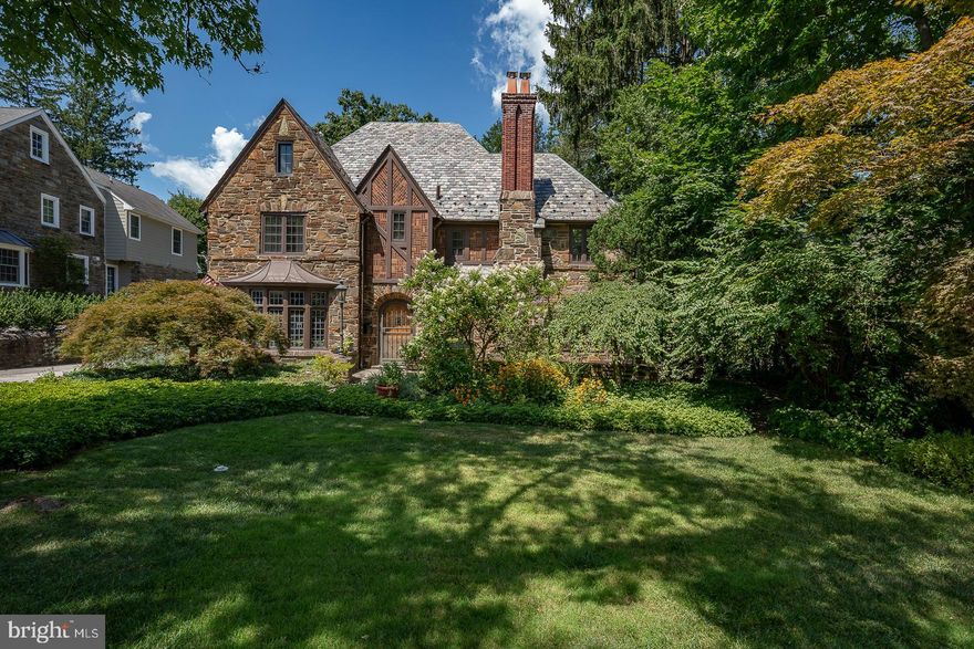 This grand stone Tutor, surrounded by lush gardens embodies the grandeur of the bygone era. Lovely moldings in all formal rooms, gleaming newly polished hardwood floors, and interesting use of color throughout. Two spectacular sets of leaded bow windows in the living room and dining room are vintage features of this unique home. The kitchen has many upgrades with copious amount of hand-crafted cabinetry. Four large bright bedrooms, a huge walk-in closet in the main bedroom, unique third-floor space and a large flat backyard are features not to be missed. This lovely home is located on one of the most desirable Wynnewood Streets. Easy access to all major roads, train, shopping, fine dining, best public and private schools. Great opportunity to own a classic beauty in a most desirable location.