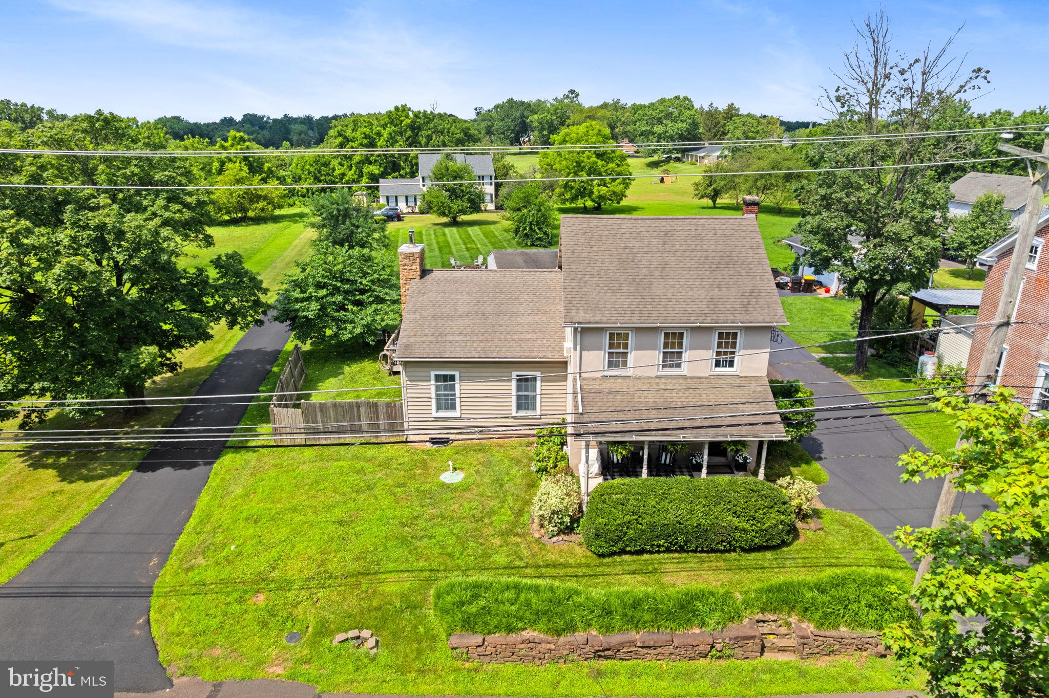Step into the charm and character of this beautifully preserved single-family home, originally built in the early 1900s and thoughtfully updated for modern living. This 3-bedroom, 1.5-bath gem welcomes you with a covered front porch and continues to impress inside with timeless hardwood floors, some dating back to the original construction. The heart of the home is the stunning family room addition, featuring a vaulted ceiling with exposed beams and a full stone wood-burning fireplace—a perfect spot for cozy evenings. The updated kitchen boasts stainless steel appliances and flows easily into the main living spaces, while the convenience of a main floor laundry and powder room adds modern functionality. Upstairs, you’ll find three generously sized bedrooms and a full bath. The full basement provides ample storage, and the oversized one-car garage offers even more space for hobbies or equipment. Set on nearly half an acre, the backyard is a true retreat, perfect for unwinding in nature, with established Concord grape bushes ready for picking. Public water and sewer, a back-up generator for peace of mind, and a fantastic location within walking distance to two popular local restaurants, and close to Skippack Village - make this home the perfect blend of old-world charm and everyday comfort. **1 Yr APHW Home Warranty is included at final settlement.