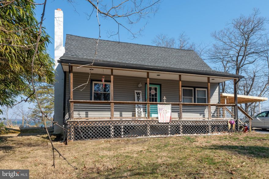 AMAZING VIEWS!!!   LOVELY SIDE YARD WITH COVERED PATIO AND DECK TO ENJOY THE VEIWS.  INSIDE THE KITCHEN, SUNROOM AND BOTH UPSTAIRS BEDROOMS LOOK RIGHT OUT OVER THE WATER.   The septic and well are newer.  Flooring is newer, Freshly painted, Electric is updated.  Path down to the waters edge.  (cannot build a pier) Don't miss this amazing home....you won't find many waterfront homes under 500!