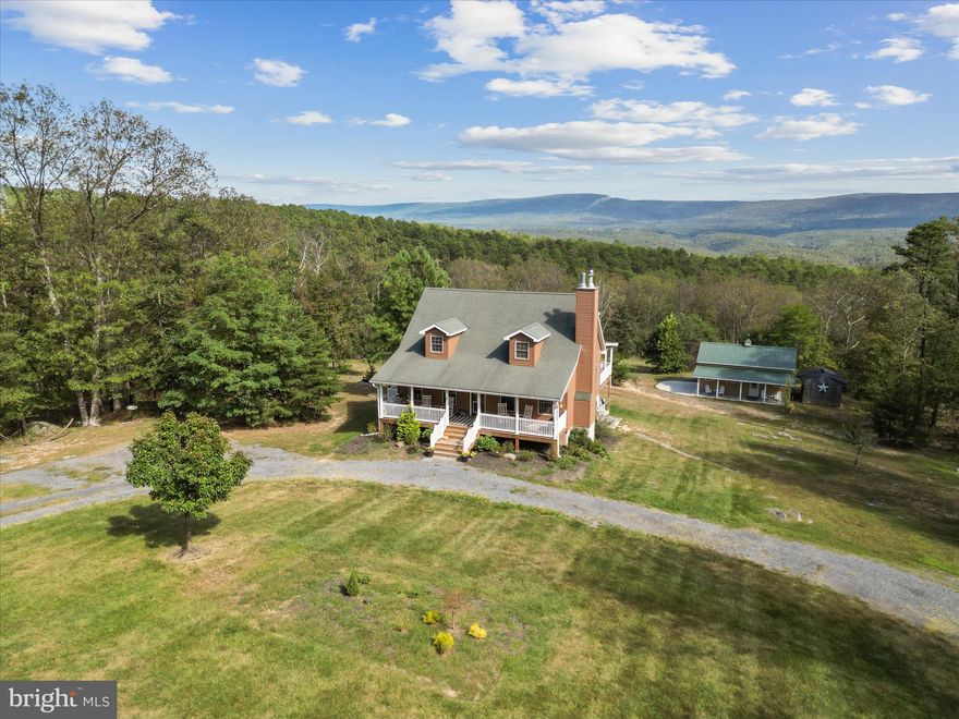 Experience refined mountain living with this stunning 30.17-acre estate, where modern comfort meets the unmatched beauty of West Virginia’s landscape. Designed in 2008 as a weekend retreat and later cherished as a permanent residence, this property blends elegance, privacy, and panoramic mountain views into a one-of-a-kind offering. Step inside this 4BD/3.5BA home to discover a thoughtfully finished walkout basement, complete with multi-use space great for home offices, a full bath, and additional living space ideal for hosting family and guests. The main level impresses with soaring ceilings, a striking wood-burning fireplace, and a gourmet chef’s kitchen outfitted for both everyday living and effortless entertaining. The primary suite is a true retreat with its own spa-inspired ensuite, while a convenient half bath and main-level laundry add ease and practicality.
The top level offers additional bedrooms and another full bath, along with a private balcony where you can take in sweeping views of the wild and wonderful West Virginia mountains. Outdoors, flourishing fruit trees and cleared grounds set the stage for curated landscaping, gardens, or simply enjoying the natural beauty in complete seclusion—no neighbors in sight. Perfectly positioned, the property is only 20 minutes to the charming town of Wardensville with its local shopping, dining, and vibrant organic farmers market, and just 30 minutes to Winchester, VA, for expanded conveniences. This is more than a home—it’s a mountain sanctuary designed for those who seek both sophistication and solitude. Schedule a private tour today and make this exceptional estate your own.