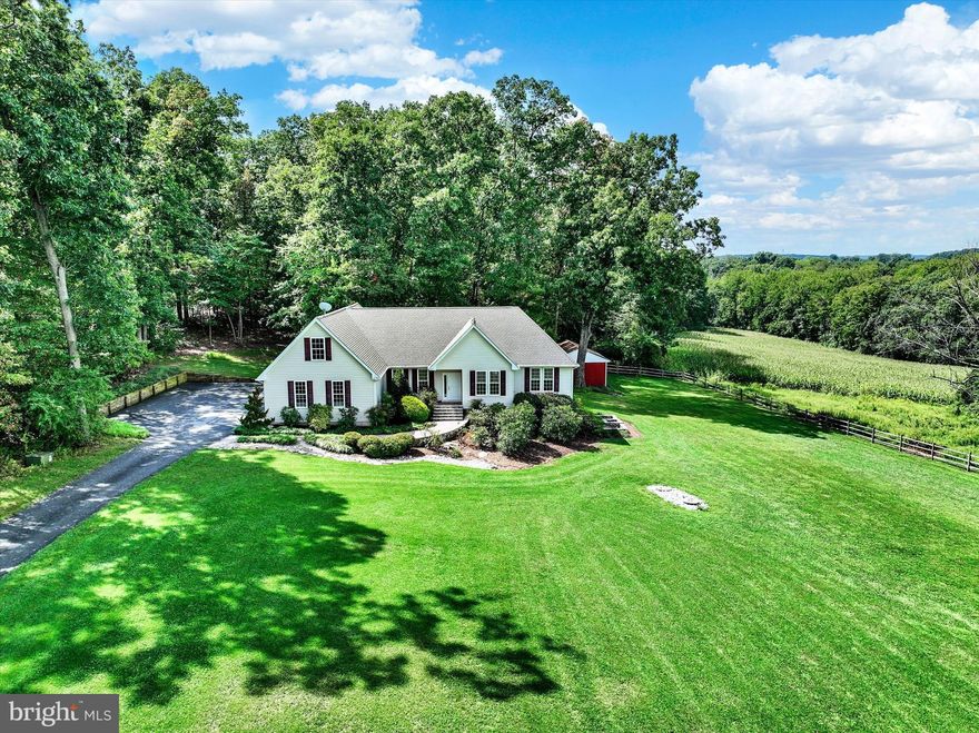NEW WEEKLY $10K PRICE CUTS. TO HELP OFFSET HIGHER MORTGAGE COSTS, SELLER WILL DROP THE PRICE BY $10,000 EVERY WEDNESDAY UNTIL FURTHER NOTICE.

This property will capture you from the moment you turn in the driveway. Beautifully sited with a wooded backdrop and expansive views of adjoining preserved farmland, the custom home exudes curb appeal. And features like the expanded parking tell you right away that attention has been given to enhancing both daily life and entertaining. Admire the professional landscaping and hardscaping, then enter the front door to the foyer and impressive great room beyond. The cathedral ceiling, gas fireplace, and open floor plan welcome you in. The scale, natural light, upgraded moldings and fixtures, warm wood flooring, and beautiful views create an irresistible aesthetic. Yet beyond the visual appeal and attention to detail is the exceptional practicality of this unique home. It's the perfect private, comfortable get-away for you and a fantastic spot for hosting family and friends. The kitchen has granite and stainless appliances, upgraded oak cabinetry, and a breakfast bar. There's a primary suite plus two additional bedrooms on the main level, and the baths are nicely appointed with higher-end features. The den, dining room, spacious mudroom/laundry room, and powder room round out the main floor. Both the kitchen and primary bedroom open to a rear deck that is ideal for nature lovers and birders. Enjoy woodpeckers, owls, hummingbirds, and native woodland creatures right outside your door. For larger gatherings or recreation, the finished lower level offers an expansive space with a bar/kitchen area, dedicated wine storage room, and light-filled walk-out to a fantastic patio with built-in firepit. Picture game-day or holiday gatherings enjoying both the indoor and outdoor spaces. In addition, the lower level offers two more bedrooms with great natural light and a full bath. But we're not finished yet! Do you need hobby or workshop space or a spot for some of those large toys with engines? There's a large workshop with a built-in counter and sink on the lower level plus an oversized two-car attached garage. Both benefit from a handy built-in air compressor. Plus a 30' x 20' outbuilding/garage with 10-foot high overhead doors provides extra work and storage space. All that plus a coveted location with easy access to I-83, the NCR bike trail, the Gunpowder River, local breweries and wineries, and the highly rated Hereford School District.