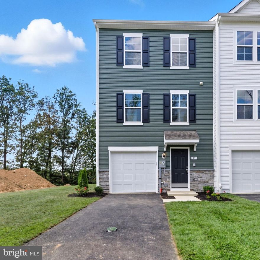 END HOME! Don't miss the only brand new end one car garage end home with 4 bedrooms. This unique townhome offers private views off the FRONT and BACK of home. Front of home offers 40 ft. asphalt driveway that holds 2 vehicles. Front, back and side yard is fully sodded creating an instant beautiful yard. Home features Forest Green vinyl siding with a contrasting stacked stone watertable. Home includes a Wi-Fi enabled garage door opener with outside keypad and 2 remotes. Front entryway has landscaping package and inviting covered entryway. Step inside to durable waterproof luxury vinyl plank flooring and a spacious coat closet. First bedroom of four is located on the lower level and includes a private full bathroom with step in ceramic tile shower. This bedroom has a walk out exit to the backyard. Climb the 40"wide carpeted stairs to the main level featuring an open kitchen/family room and dining room. The kitchen is the star on this floor with an 8.5 ft. quartz prep island with single bowl undermount stainless sink with garbage disposal , full overlay painted taupe (Willow) cabinets with full 42" upper cabinets that reach the ceiling. Cabinets feature Elara black matte knobs which accent 2 charming black pendant lights above the prep island and the matte black gooseneck kitchen faucet with pull down sprayer. Upgraded Calacatta Duolina Quartz countertops are accented by 3 x 8 Blanco offset pattern ceramic tile backsplash. The chef in your home will love the stainless range oven with two FlexHeat™ Dual Radiant Elements with oven temperature sensor for more even baking. Electric touch control Microwave above oven includes a vented hood that vents to the outside. Quiet dishwasher is stainless inside and out and with a pocket handle makes clean up a breeze. Home also includes a Side by Side refrigerator with filtered water and ice dispensing. Pantry sits right next to fridge keeping you kitchen storage efficient. Prep island has seating for 4 counter height bar stools. If you are looking for lots of light - this home will not disappoint, 4 windows in family room allow natural light and beautiful daytime views to enjoy. The eat in kitchen easily fits a kitchen table and offers a 10 x 14 composite deck off the slider in dining area. Convenient powder room on this level with the completely open floor plan will impress your family and friends. Upstairs the primary offers private views off the back of the home and a vaulted ceiling. Primary bath offers a step in ceramic tile shower with glass corner shelf and spacious cultured marble vanity top. Your towels and sheets will have a home in the primary linen closet just outside the primary bath. Walk in closet, pre-wire for ceiling fan/light combo and data port for internet are included in the primary suite. Secondary bedrooms offer private views from bedroom windows and wall closets. Each bedroom is prewired for a ceiling fan/light combo. Hall bath offers a ceramic tile tub-shower combo with elegant glass corner storage shelf. Across from hall bath is laundry closet with washer-dryer connections and outside venting for dryer. Home is close to oversized parking area and located in quiet part of community. Community allows 2 pets and fencing subject to HOA guidelines. Home is ready to settle in late September. Appointments recommended!