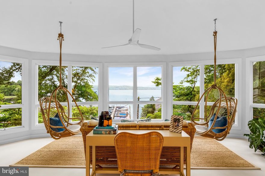 Escape to 1025 Rio Lane, a coastal getaway nestled in the  water-privileged Severn Heights neighborhood in Severna Park, less than an hour from Washington, DC without crossing the Bay Bridge! Available fully-furnished, this home is ready to be your turn-key retreat!

Featured in Annapolis Home Magazine, this stunning home was designed by Erin Paige Pitts and renovated in 2021 by Karl Wentz of Kitchen & Bath Outfitters. They reimagined this exquisite weekend, or anytime,  property into something that was intended to feel like “a cold glass of lemonade on a very hot day.”  The main level features an interplay of coastal color palettes, designer fixtures, stylish Ratan furnishings, patterned tiles, and woods elements throughout making it the home’s pièce de resistance. Its focal offers captivating views of the Severn River through a wall of windows under a canopy of skylights and high ceilings from a set of whimsical hanging chairs.

The kitchen provides the perfect offering of luxury and airiness, showcasing a center island, Silestone countertops, Subzero and Miele appliances, designer tile backsplash, a gold-plated hood, open floating shelves above, and abundant cabinetry below. Pitts’ love of making a strong statement with lighting fixtures, as showcased by two 35” Jeffan pendant lights over the dining room table, make this room feel large and intimate at the same time.  A gas fireplace surrounded by beautiful white hardwood floors and shiplap walls adds to the room’s ambiance.

Architectural digest like vignettes and cross-design elements continue throughout the private living spaces on the main level and below.  The primary bedroom offers an en-suite bathroom, built-in nightstands, and access to a deck with water views. An updated bathroom with tile throughout, along with a second bedroom featuring designer wallpaper and a built-in window bench, complete the main level. The lower level also hosts a spacious recreation room with water views, a third bedroom outfitted with four custom-built bunk beds, and a third full bathroom, ensuring ample space for guests or family members.

Mature landscaping frames the outdoor areas, providing a picturesque backdrop for relaxation and leisure on the covered patio or the deck. This idyllic retreat beckons with its breathtaking water views and proximity to convenient amenities, including a marina (with available boat slips), playground, fire pit area, and kayak storage.  1025 Rio Lane presents the perfect coastal haven to unwind and savor the beauty of your surroundings while immersing yourself in a world of luxurious coastal elegance within an hour of Washington, D.C, and only 15 minutes to charming historic downtown Annapolis!