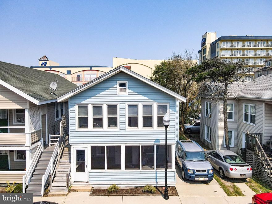 REDUCED AND READY FOR YOU TO MAKE BEACH MEMORIES!  Quintessential beach cottage with two separate apartments.  Only 3 homes off the ocean in downtown Ocean City.  An ideal opportunity -- use as is, remodel or tear down and build new.  It's up to you.  The first floor unit offers 3 bedrooms plus a sleeping nook/den, 1.5 baths, knotty pine wide plank floors, efficient kitchen and screened front porch.  The second floor unit  offers 2 bedrooms, a sleeping nook/den, 1.5 baths, efficient kitchen, fireplace and an enclosed front porch with views of the ocean.  Both units being sold furnished.  Imagine yourself listening to the rolling waves lull you to sleep, relaxing on the pristine sandy beach, walking the famous Ocean City Boardwalk, taking a leisurely stroll out for dinner to one of the  many fine restaurants the area has to offer.  You'll also find exciting water sports, amusements, and nearby shopping and casino.